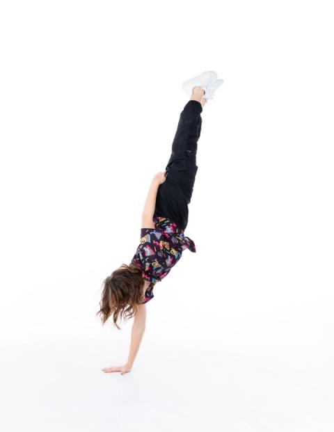 A dancer balances on one hand