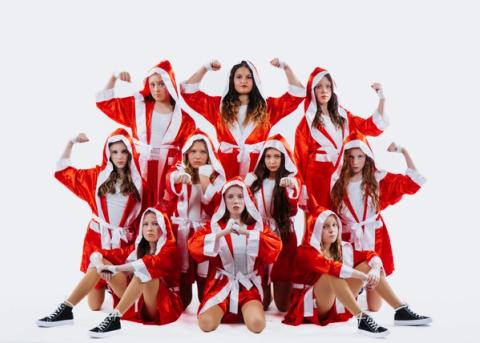 A group of dancers pose in red and white costumes