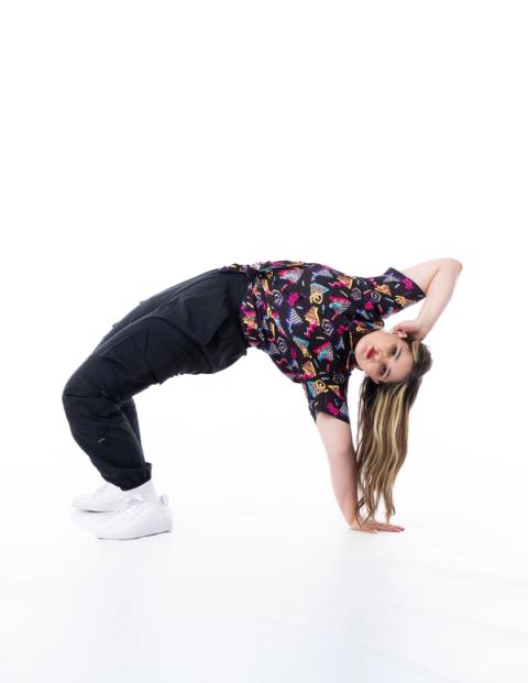 A dancer bends backward in a bridge