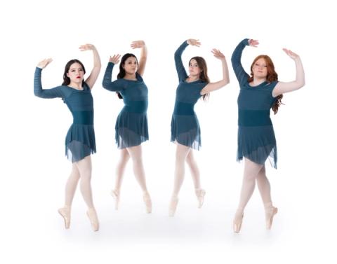 Dancers pose together in dark teal costumes