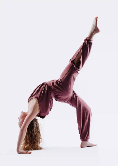 A dancer balances with one leg extended in a studio