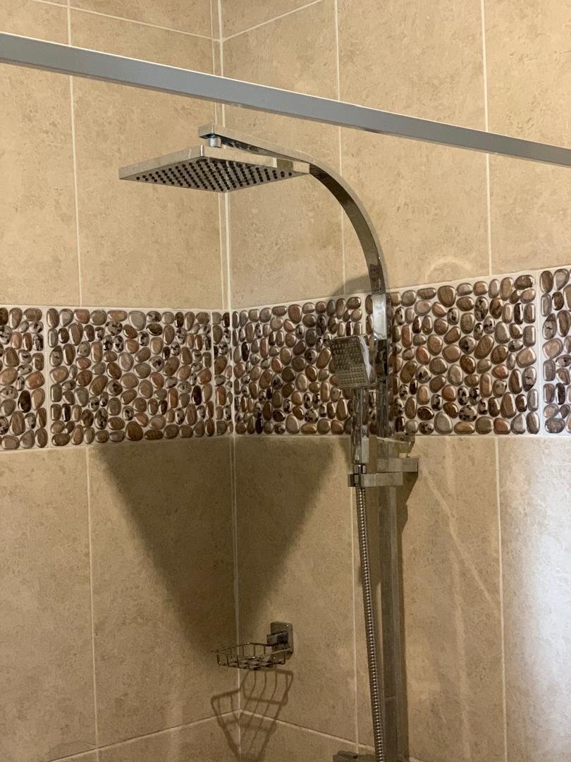 Walk-in shower with rain head and pebble tiling