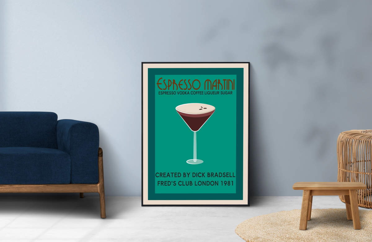 A framed Espresso Martini cocktail poster leans against a light blue wall in a modern living room. The poster features a minimalist illustration of an espresso martini on a teal background, with the title "Espresso Martini," a list of ingredients (espresso, vodka, coffee liqueur, sugar), and text crediting Dick Bradsell and Fred's Club London (1981). A navy-blue sofa sits to the left, while a small wooden stool and wicker furniture are on the right.