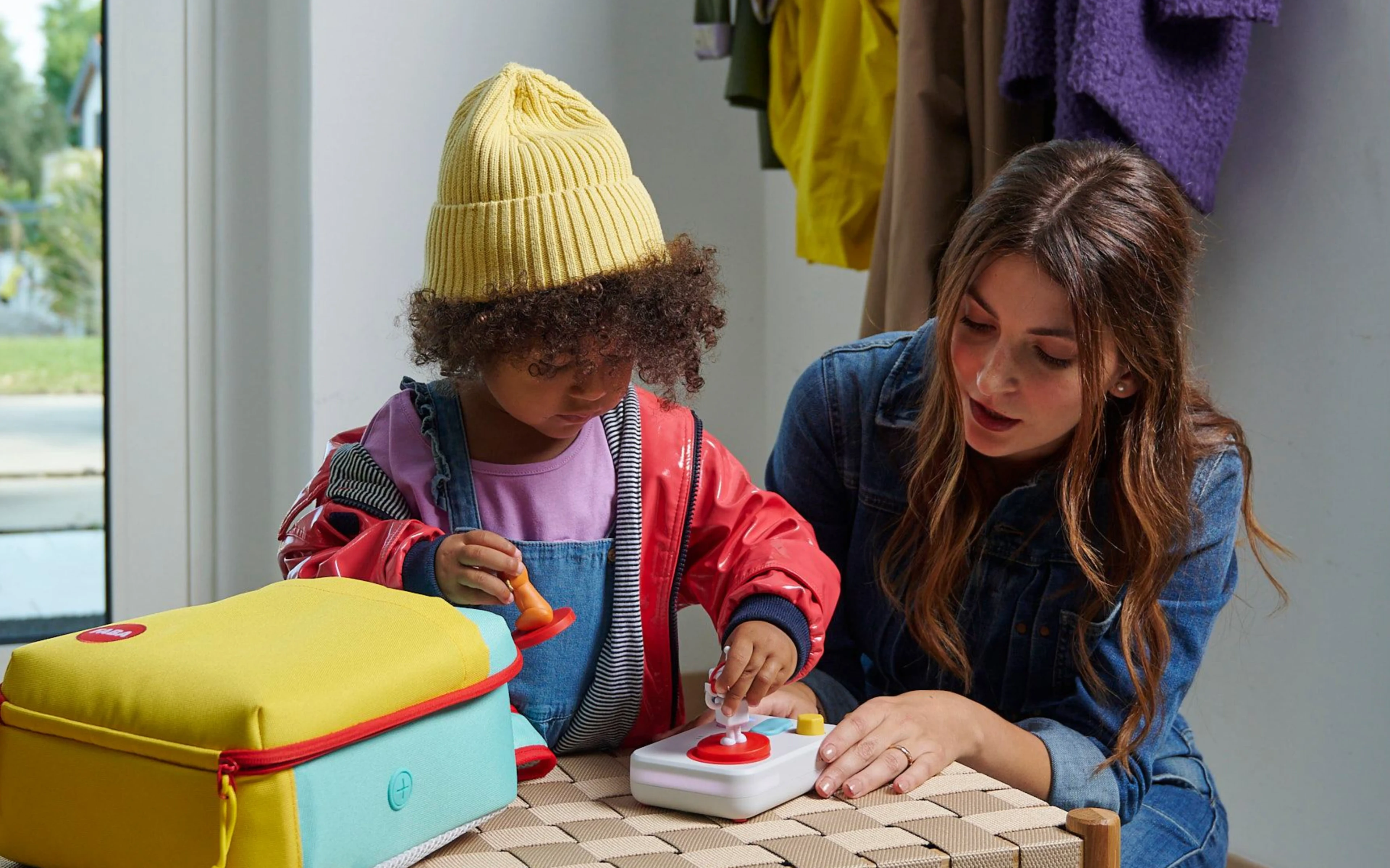 Mother and child pressing the FABA+ speaker's buttons together