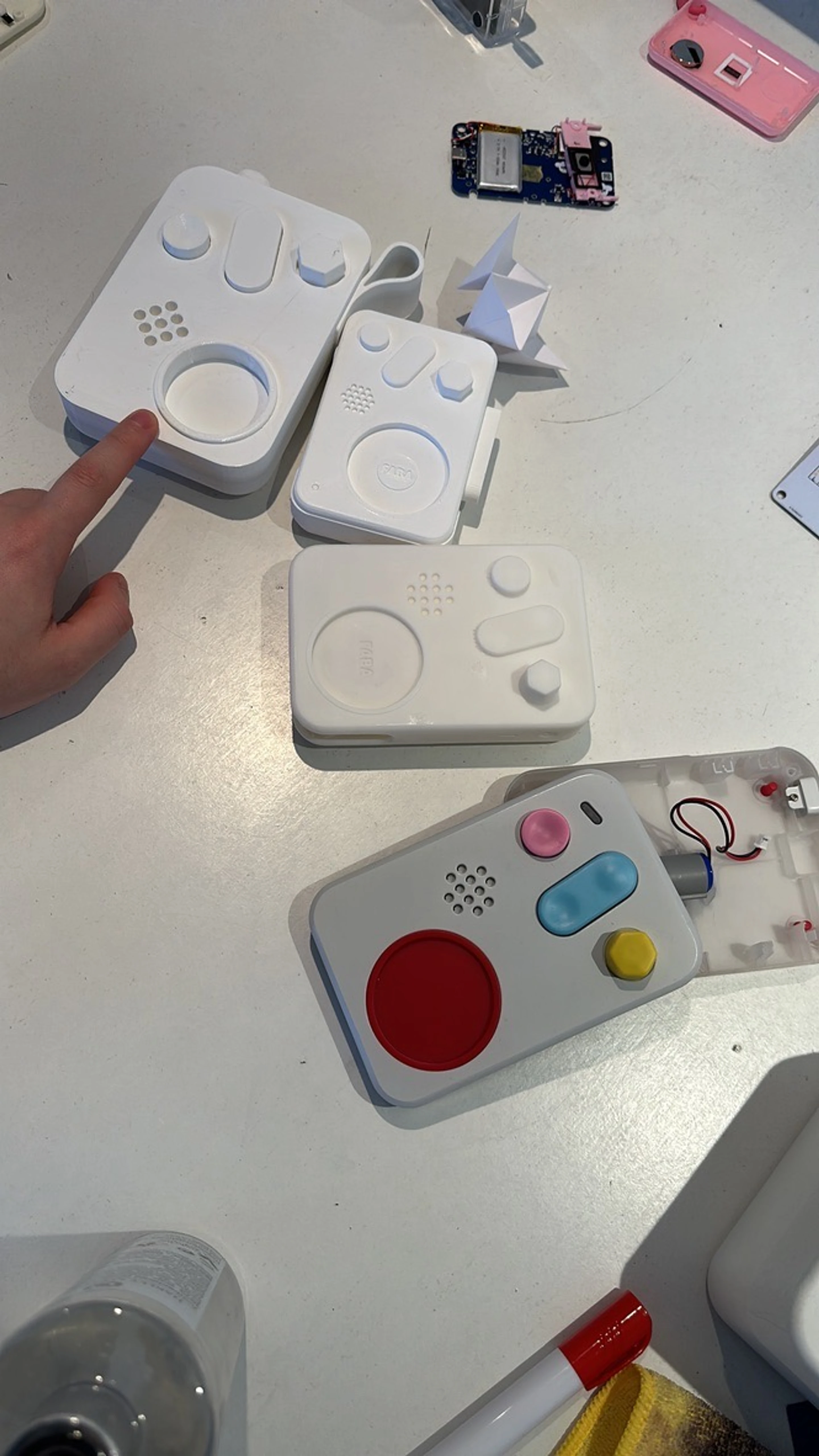 Printed handheld enclosures on the bench, one opened to its electronics