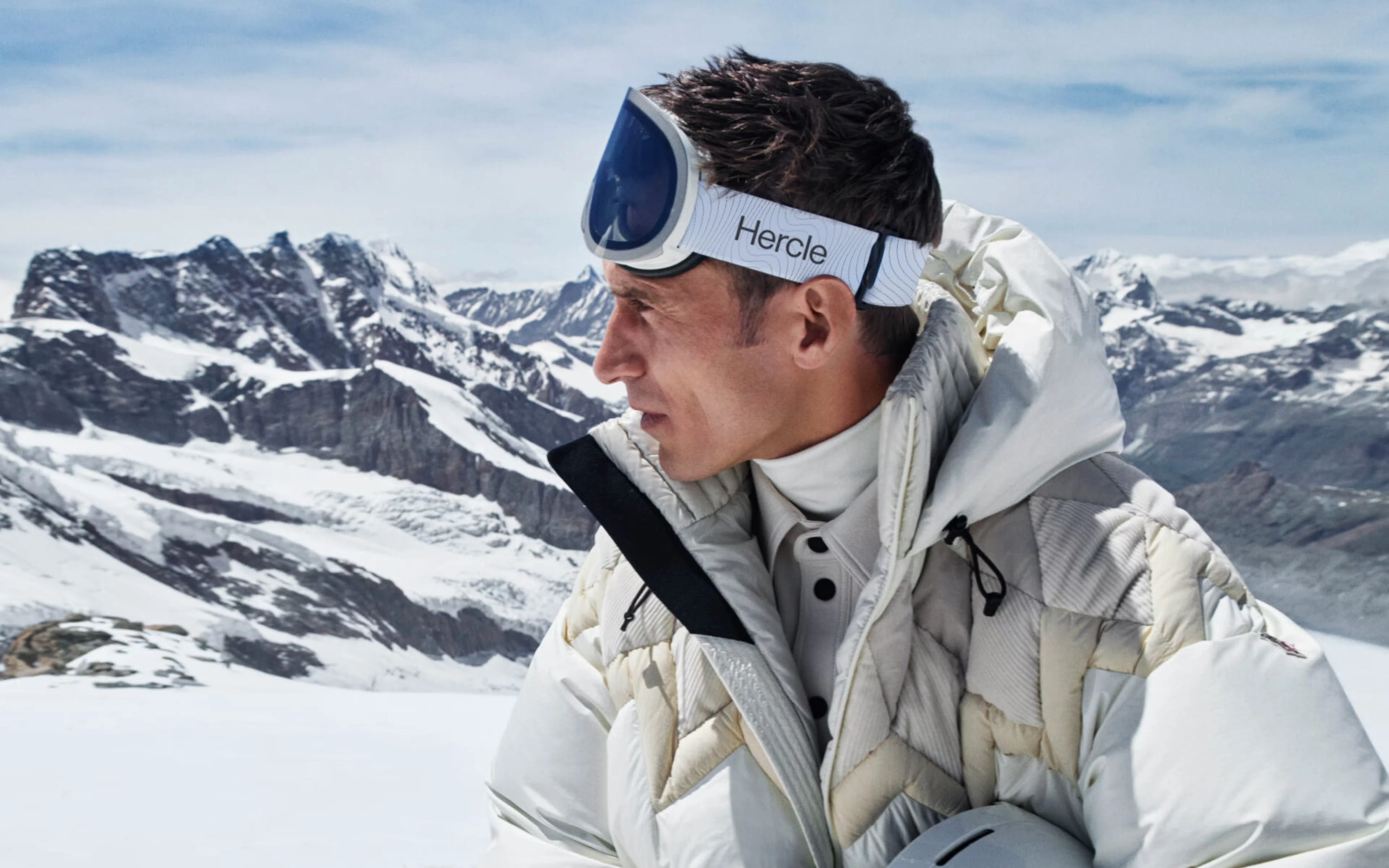Hercle branded ski jacket and goggles in the mountains