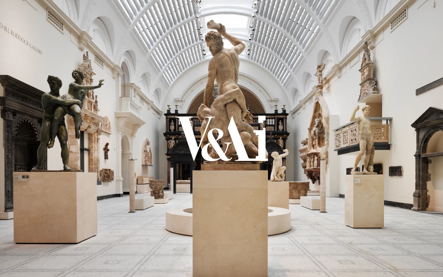 The V&Ai logo over a gallery of sculpture at the V&A