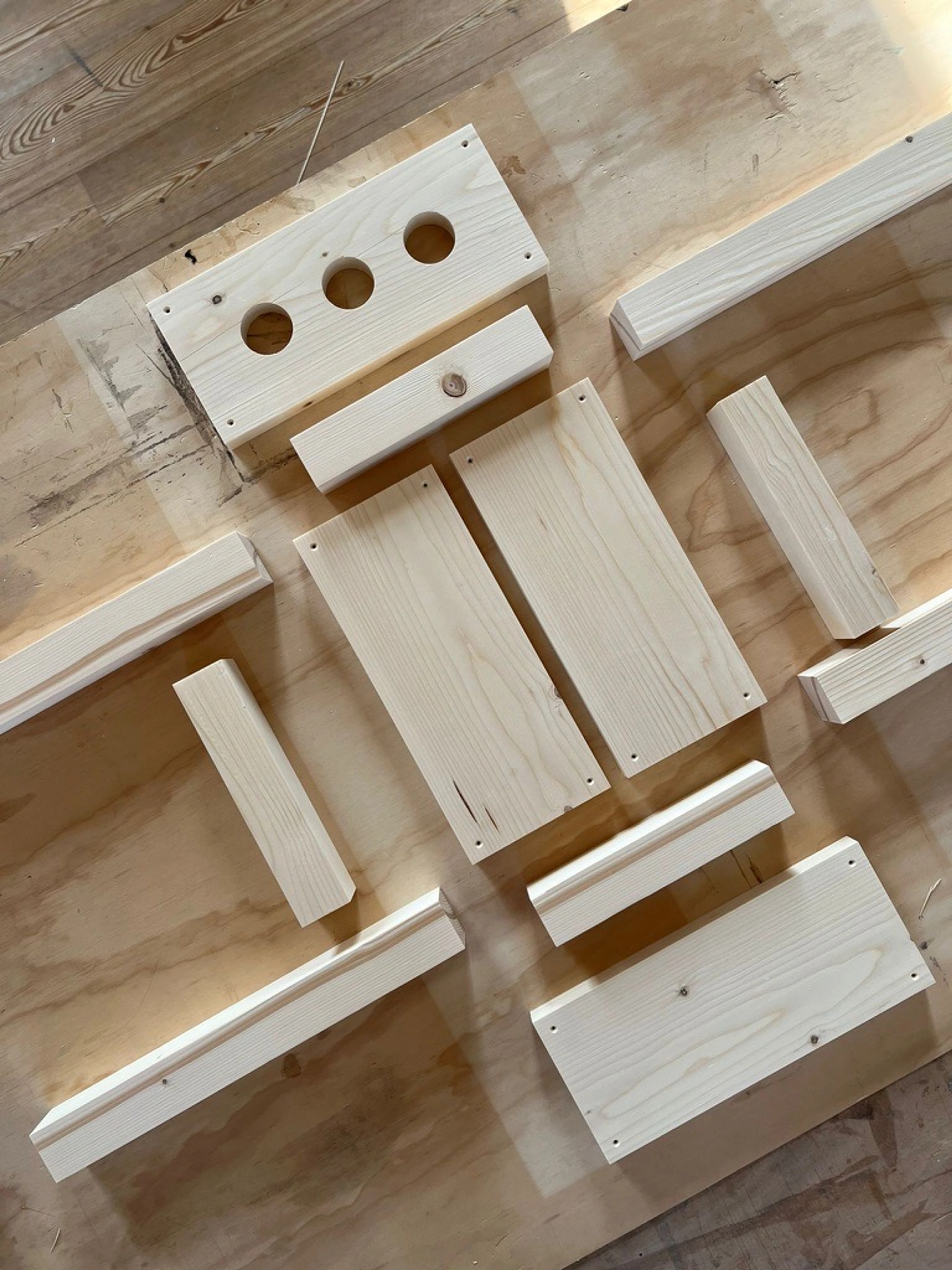Timber parts cut and laid out on plywood before assembly