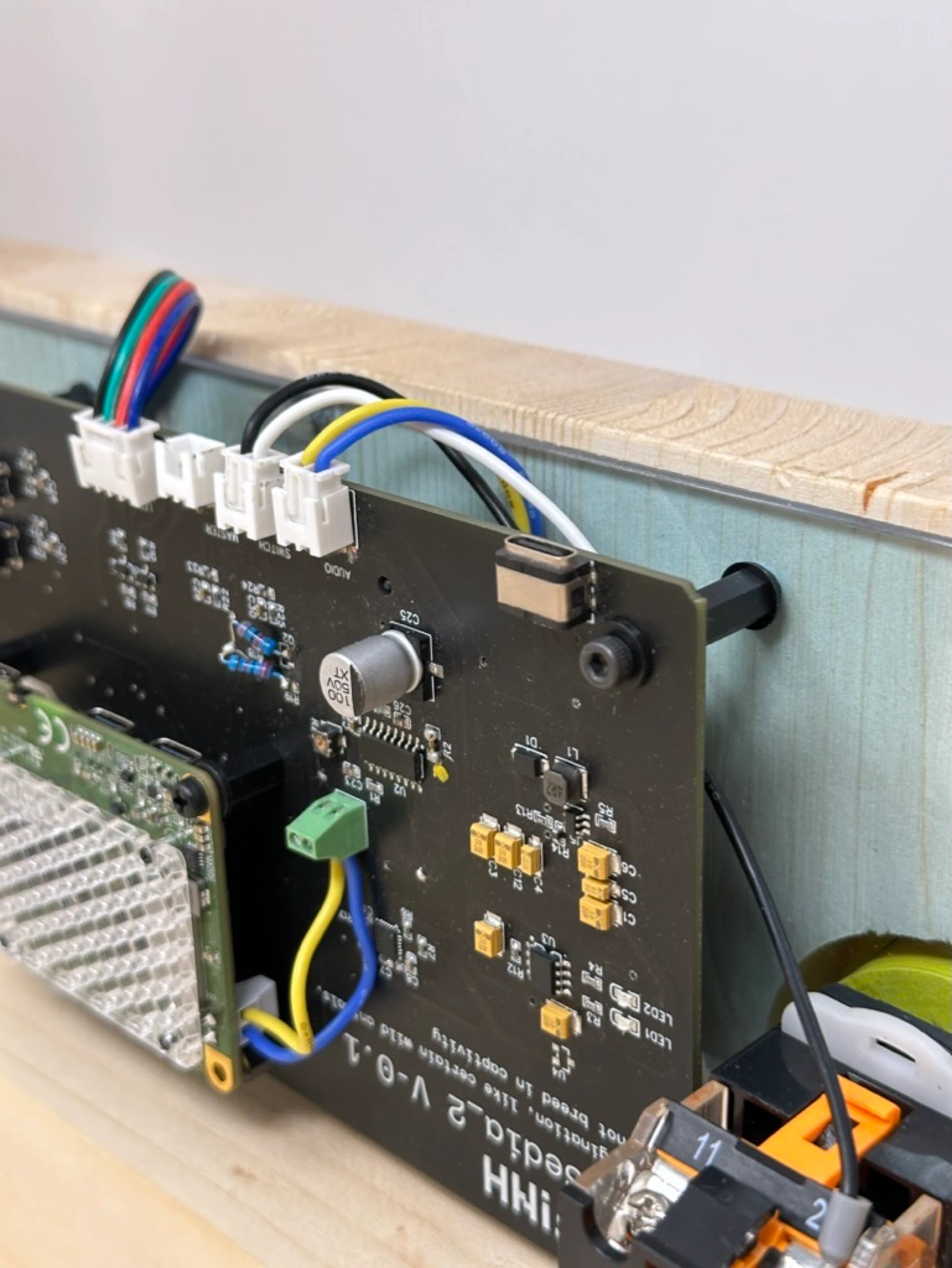 A circuit board wired up on the bench, ribbon cables run to the controls