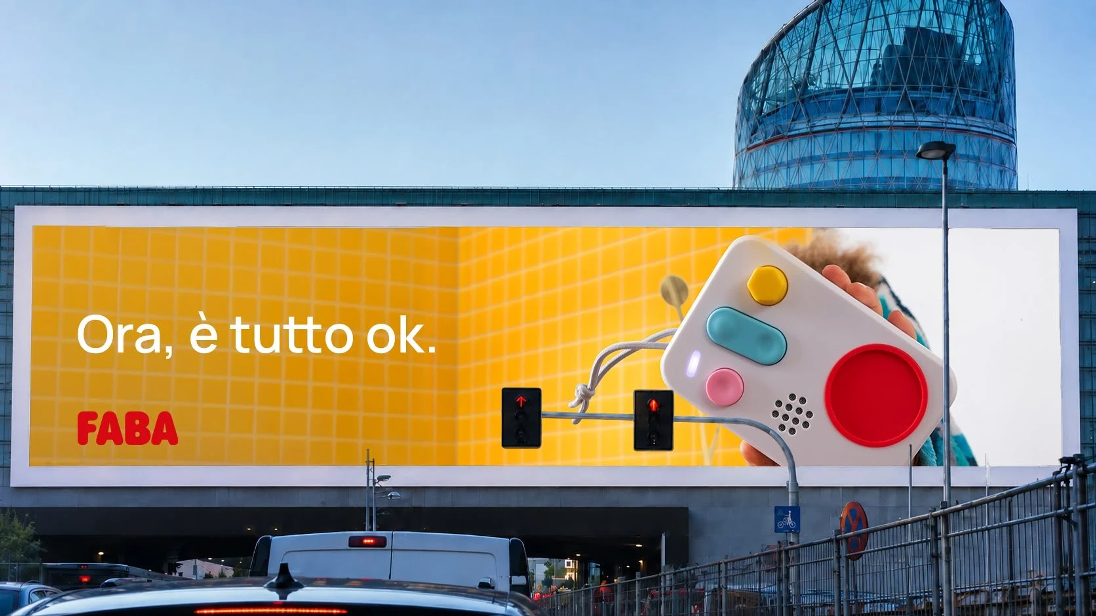 FABA billboard in Milan reading 'Ora, è tutto ok', the FABA+ speaker held up on a yellow wall above the traffic