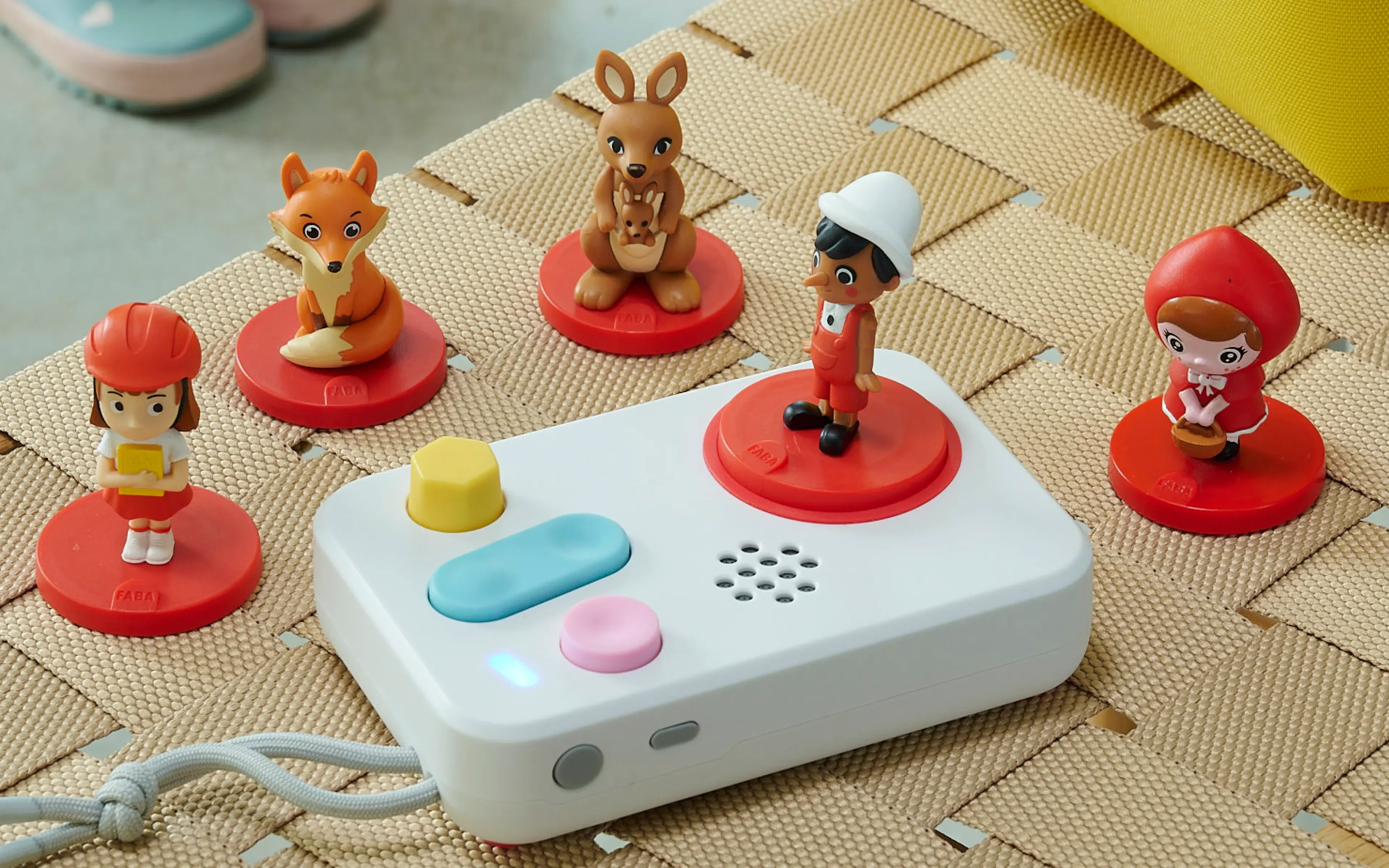 FABA+ speaker with story figurines on a woven mat