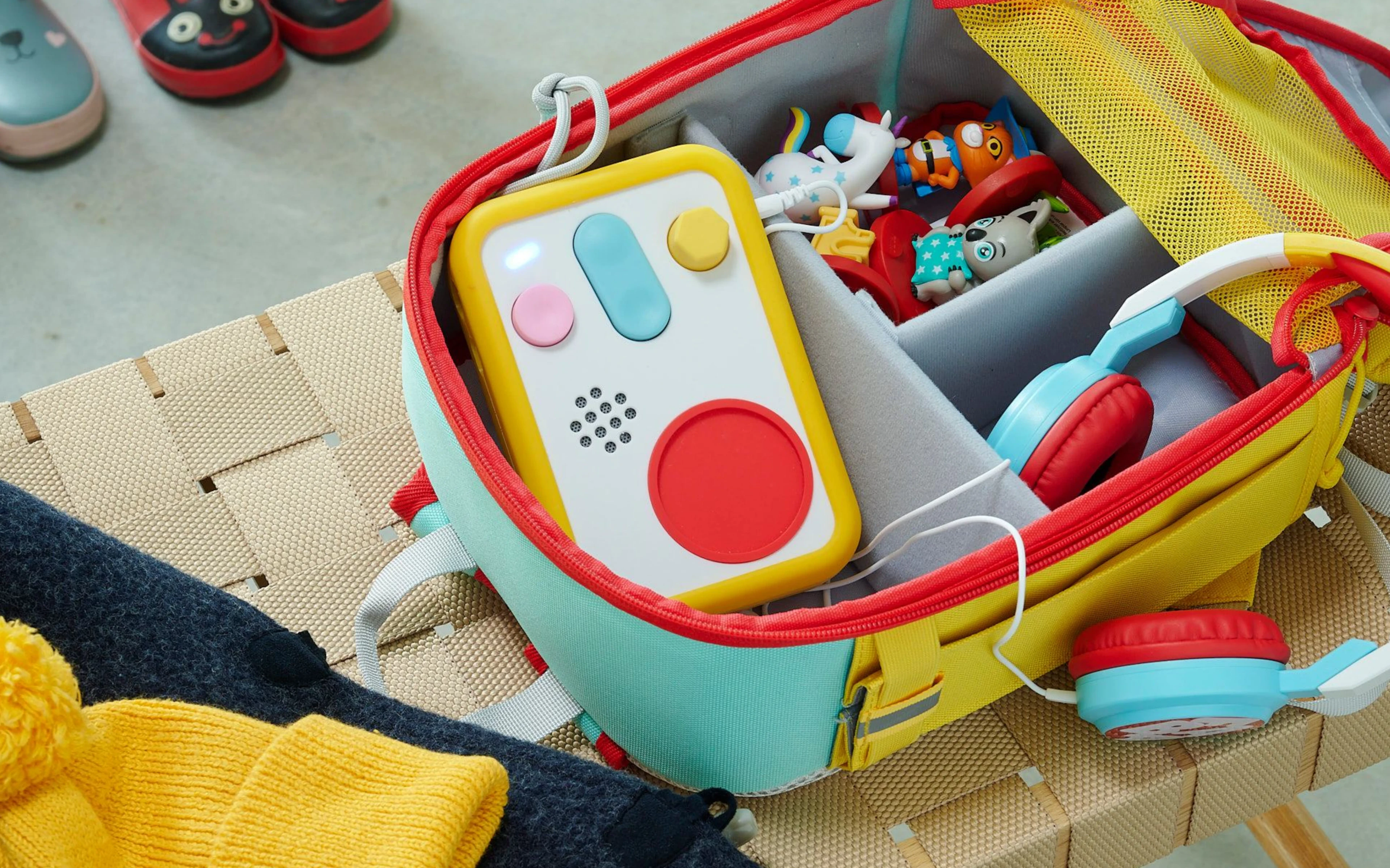 FABA+ speaker packed in a child's suitcase with headphones and toys