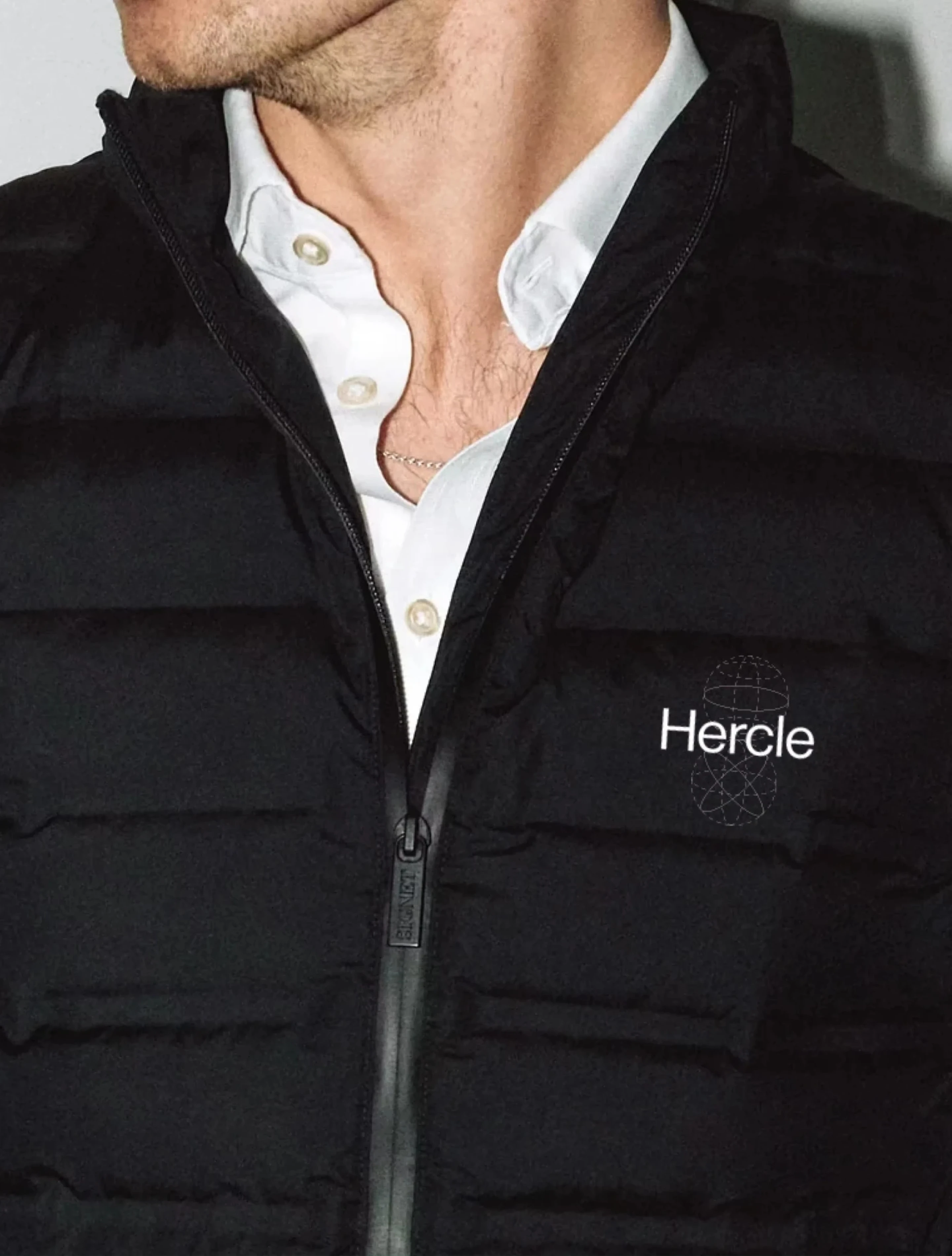 Hercle branded gilet, the wordmark and orbital mark embroidered at the chest