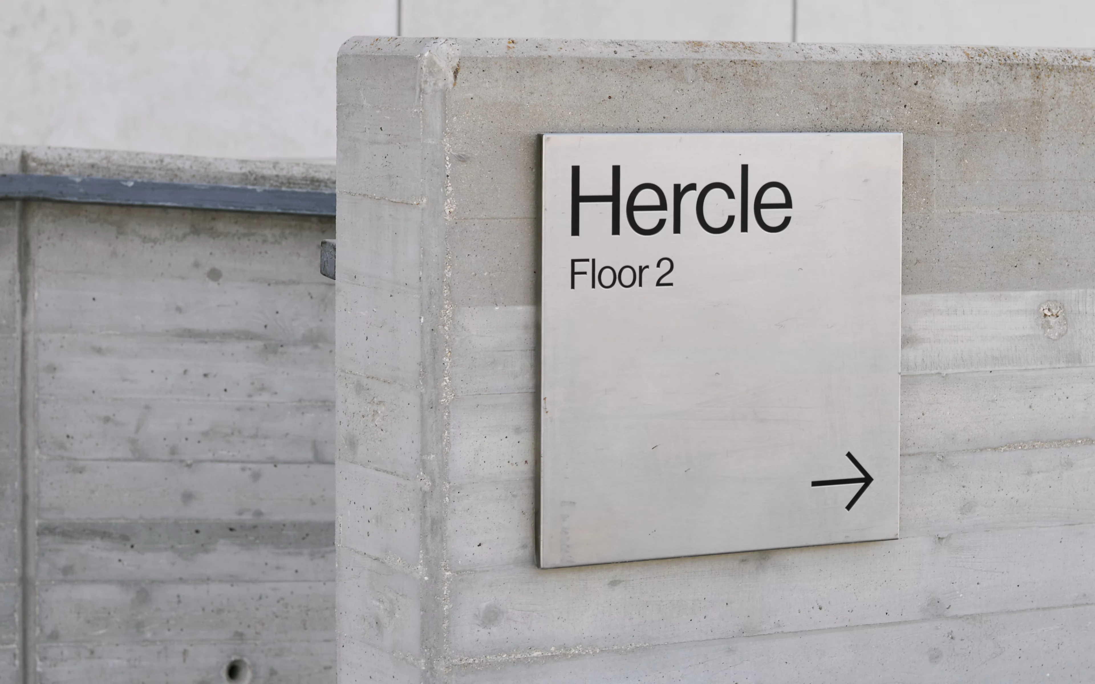 Hercle wayfinding sign on a concrete wall, Floor 2