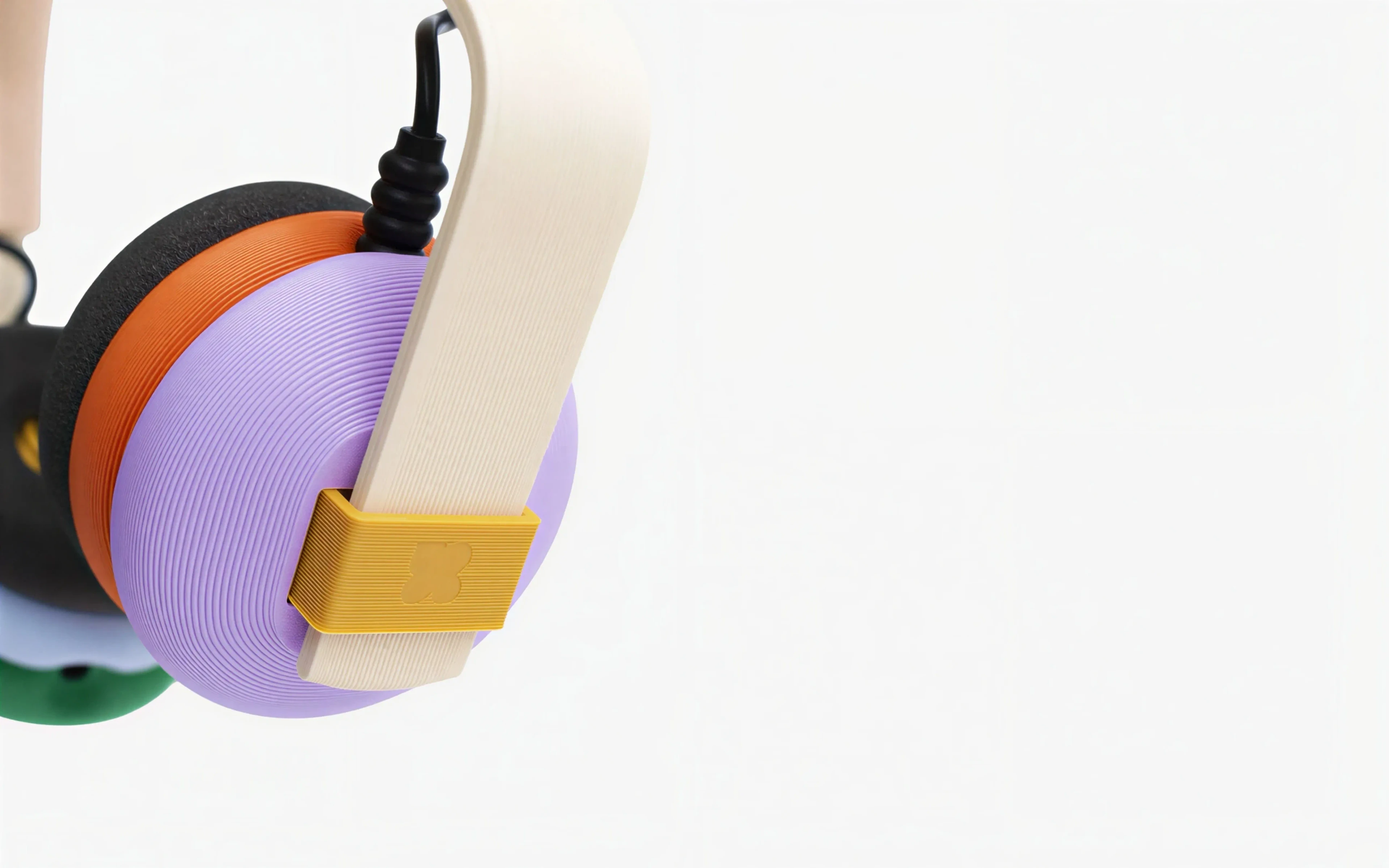 The Creator Candy headphones assembled, pink and mint against a plain ground