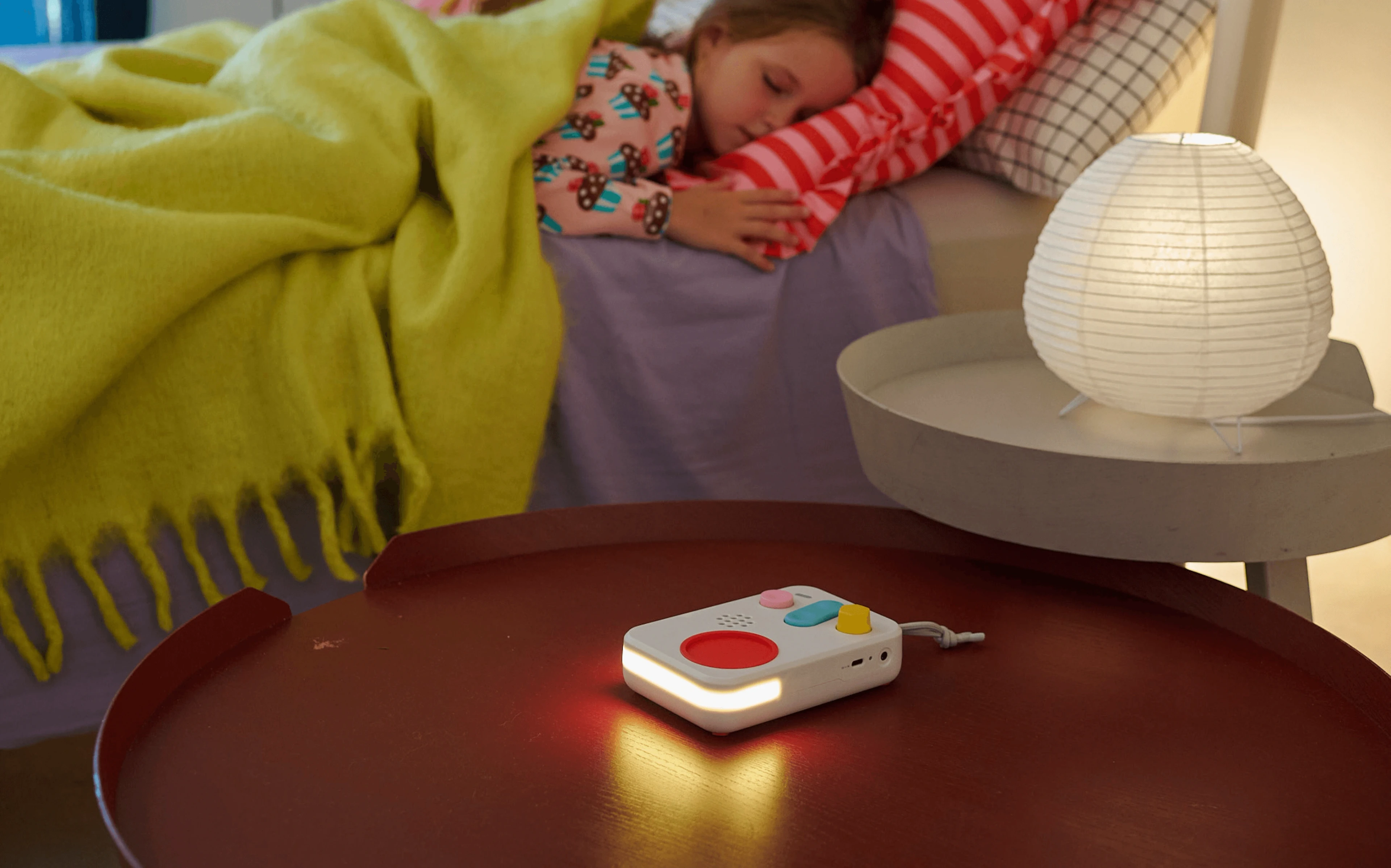 FABA+ speaker glowing as a night light on a bedside table while a child sleeps