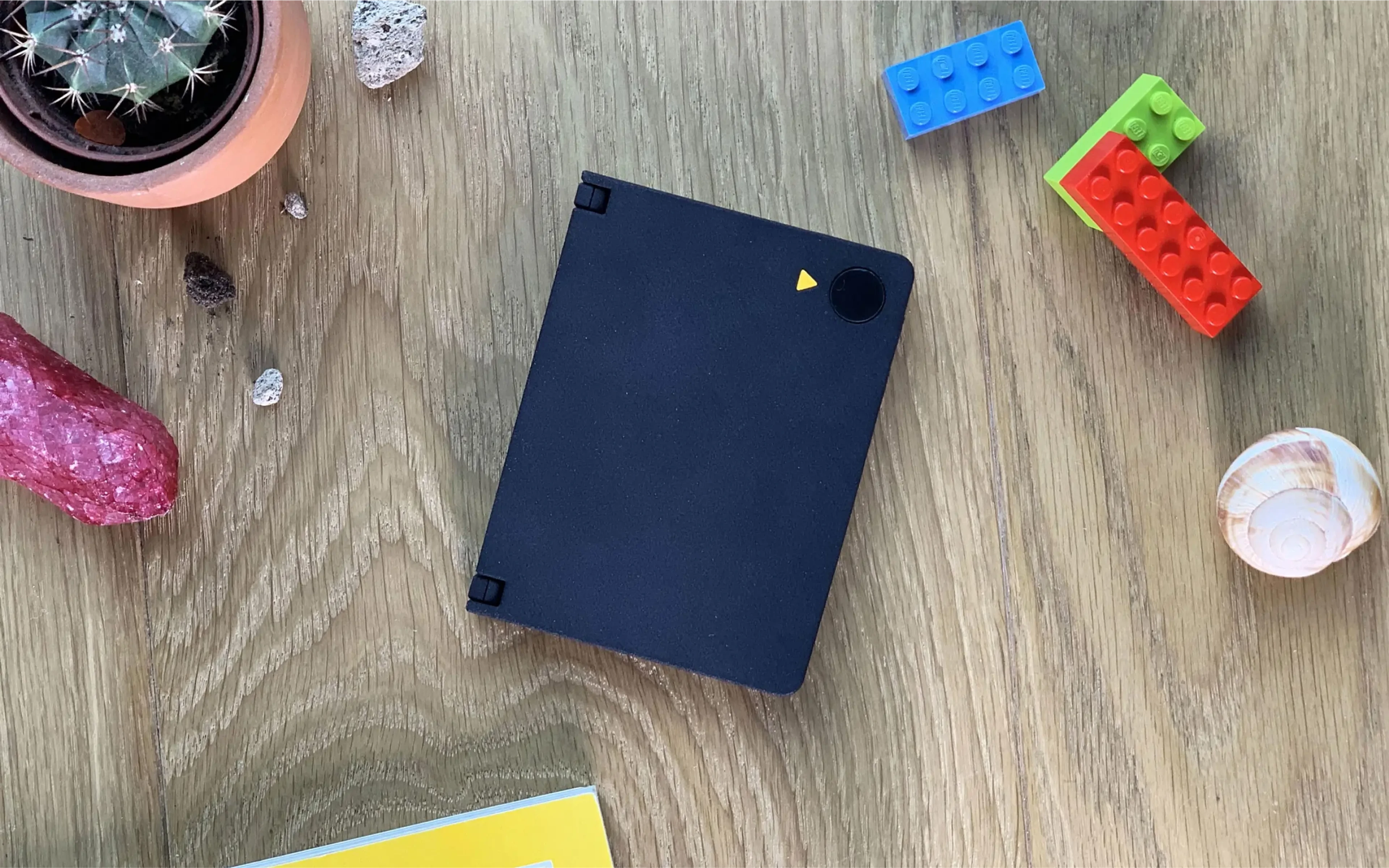 Ash AI Pokedex on a wooden desk beside Lego bricks and a crystal