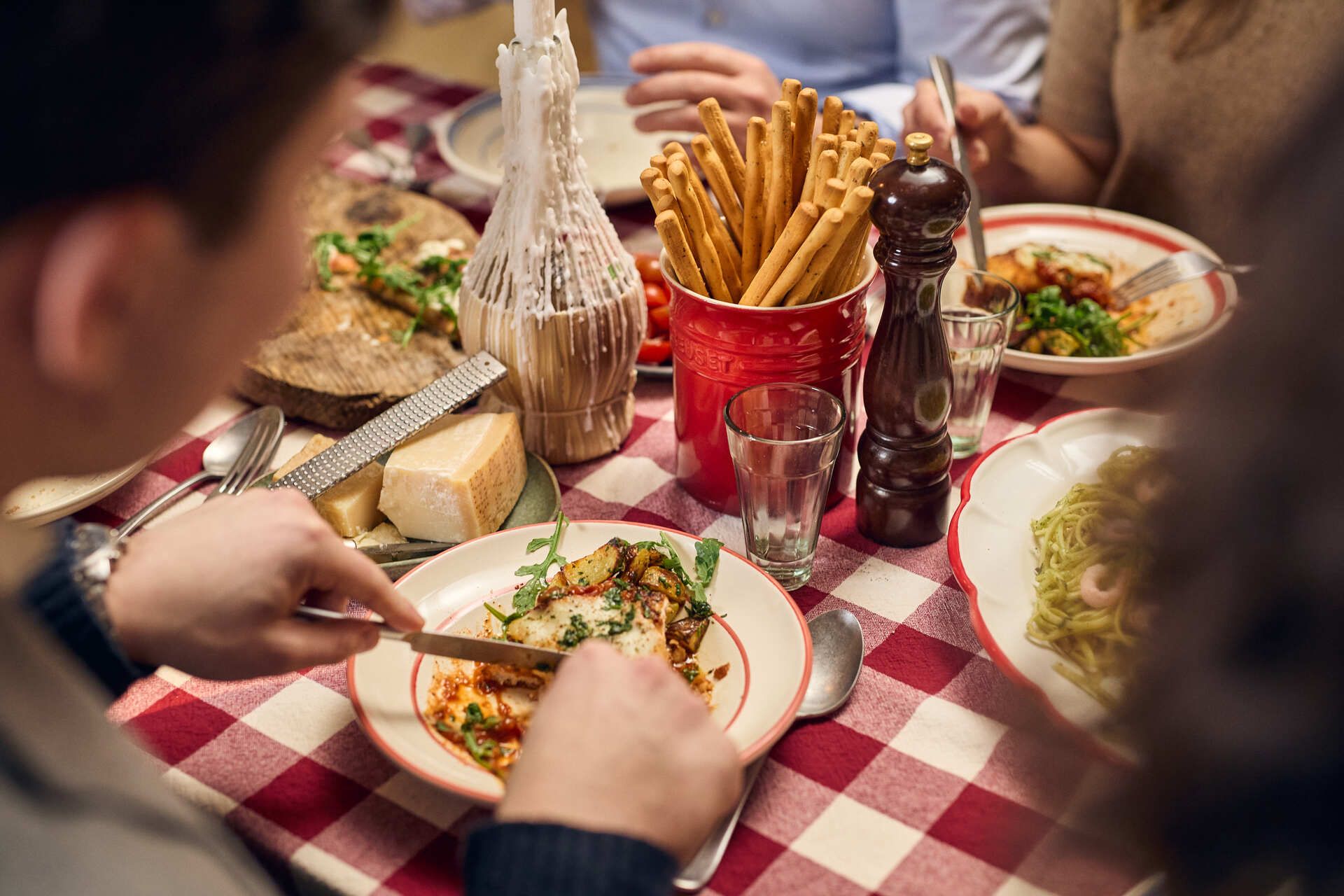 Bord med rød- og hvitrutet duk, dekket med italienske retter og delikatesser