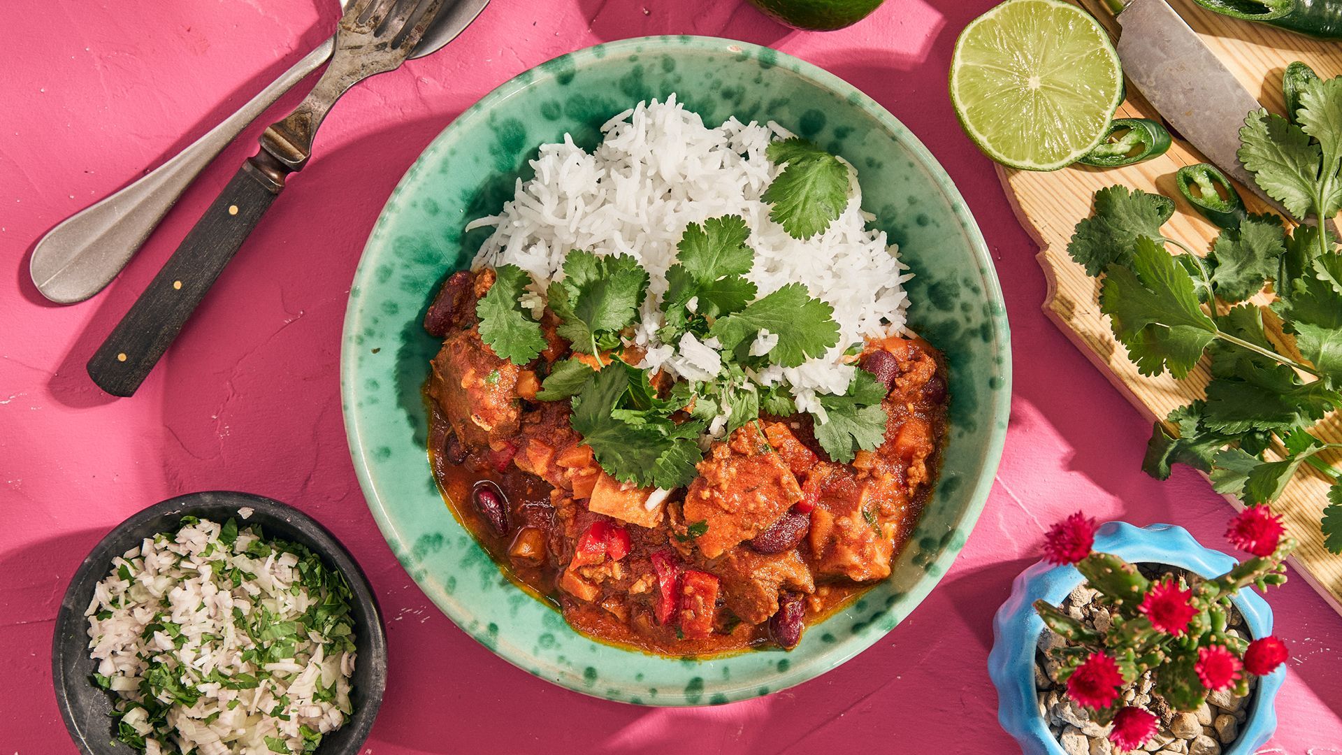 Mexicansk bønnegryte med svinebog og ris, pyntet med koriander.