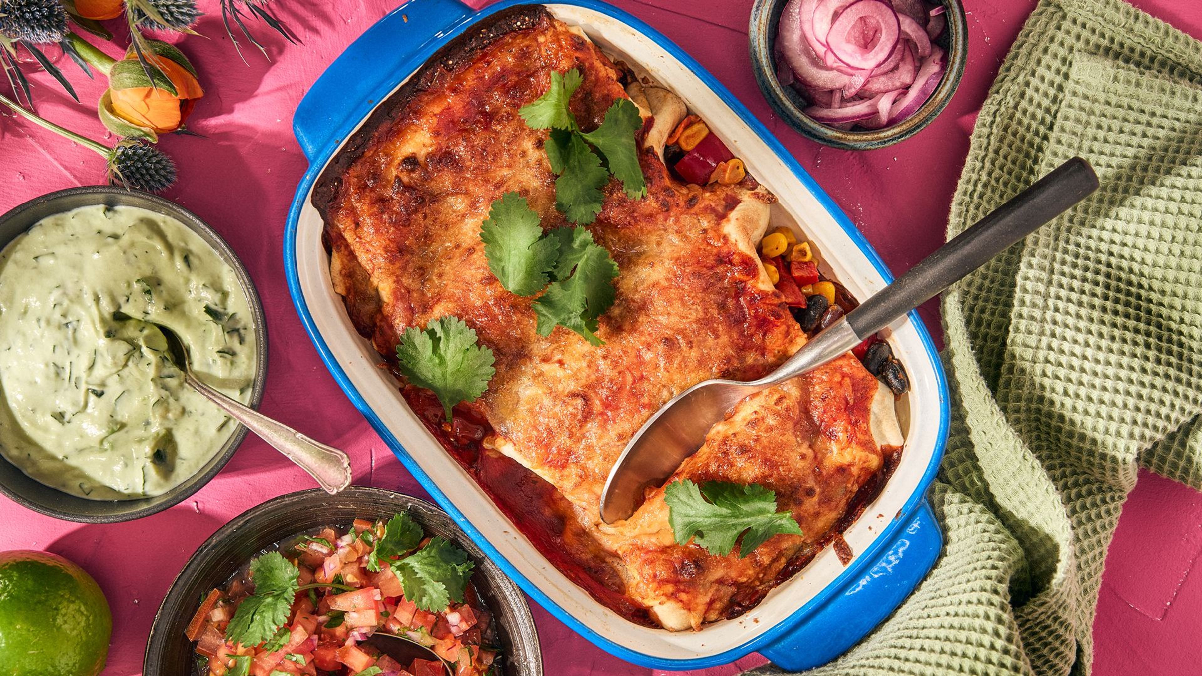 Svartbønne-enchiladas i blå form med guacamole og salsa ved siden av