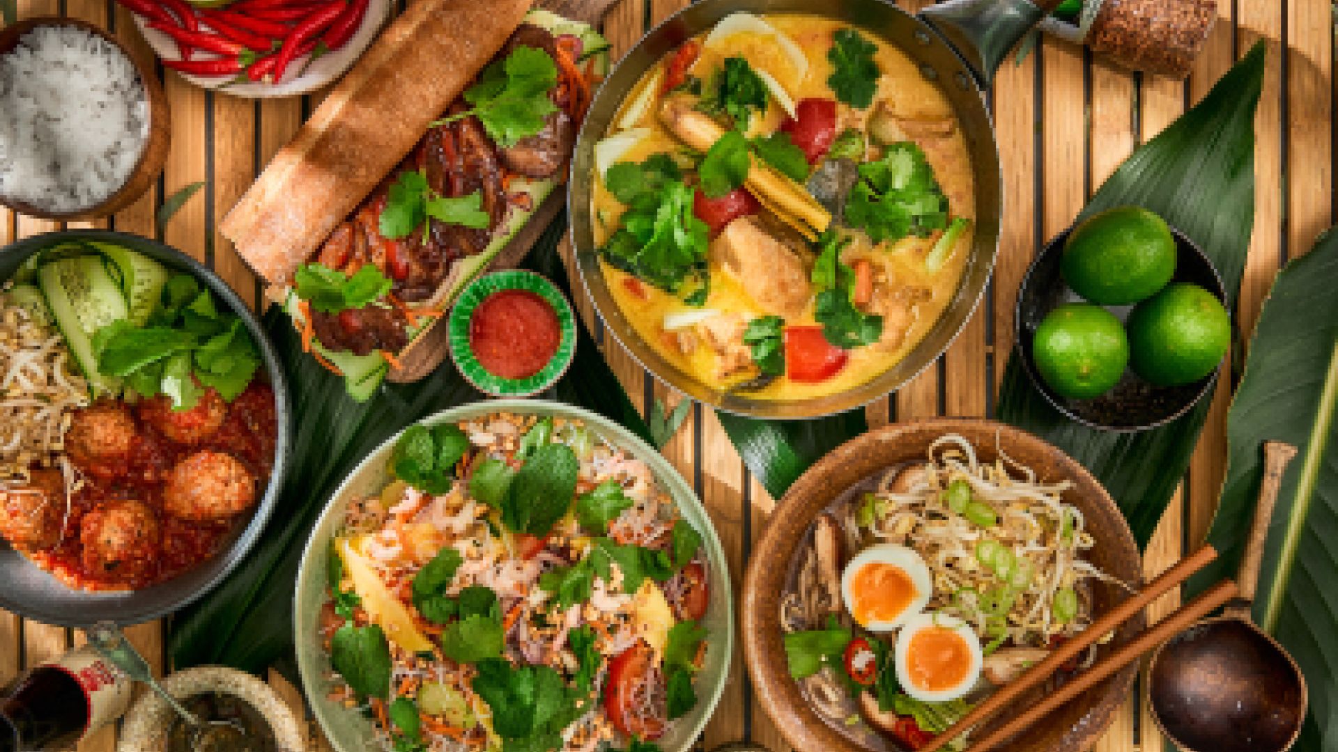 En variert middag med thailandske retter, friske urter og lime.