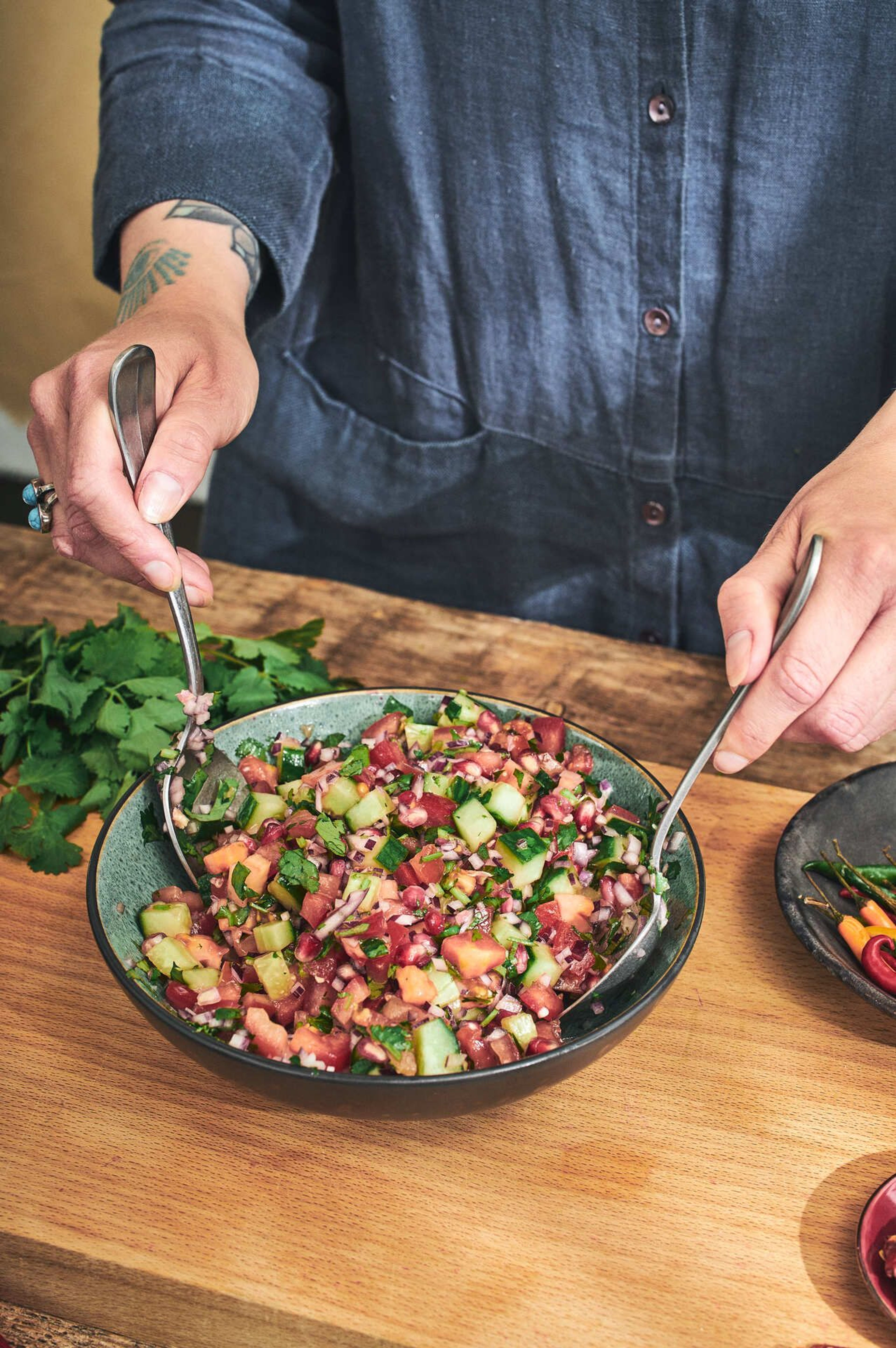 Fersk salat med agurk, tomat, løk og urter i en bolle.