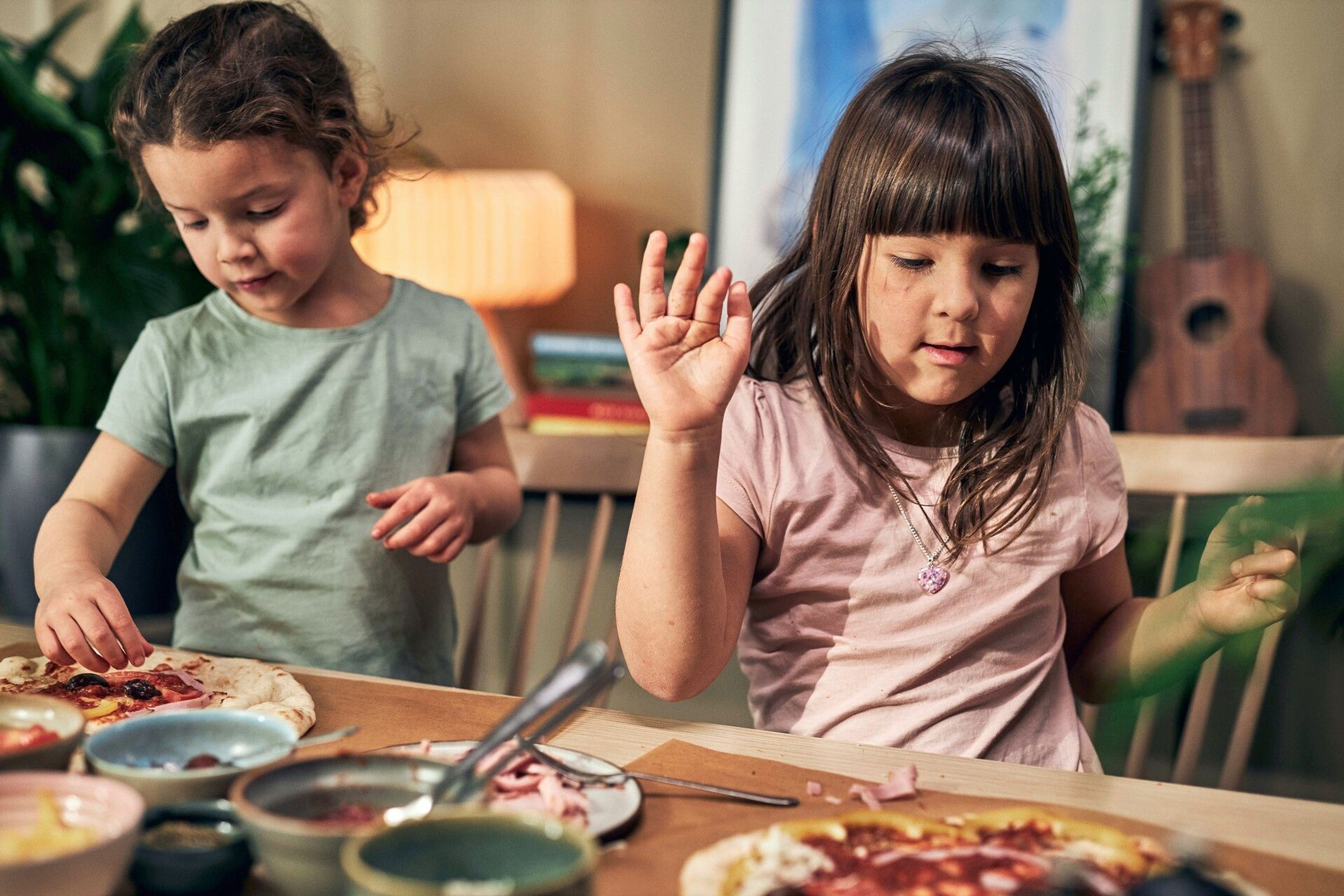 Två tjejer gör sin egen pizza med olika toppings