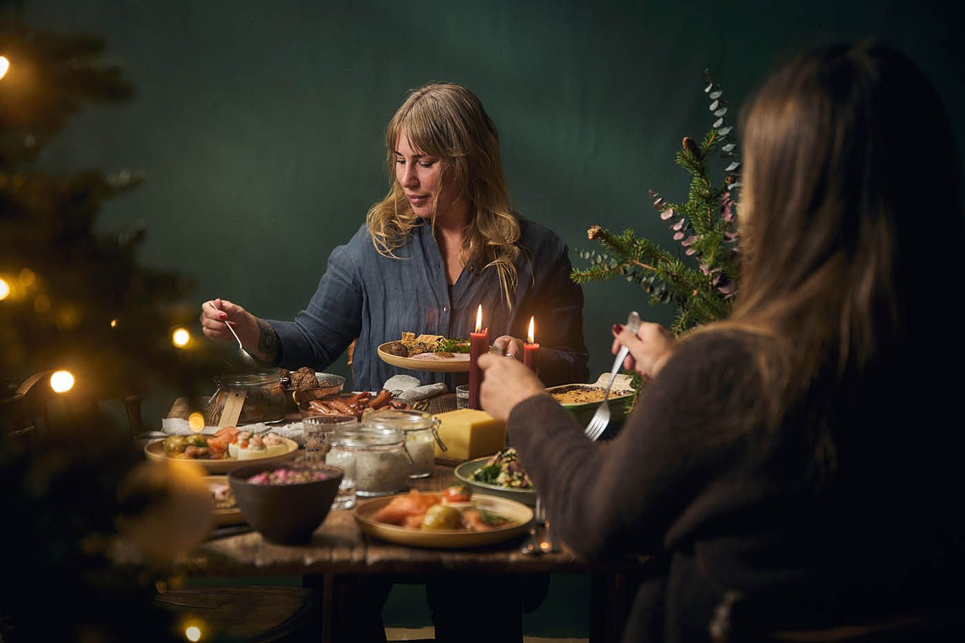 Två kvinnor tar för sig av godsaker från Linas Julbord