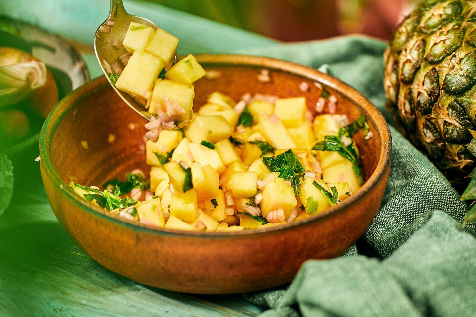 En skål med ananassalsa och färska örter