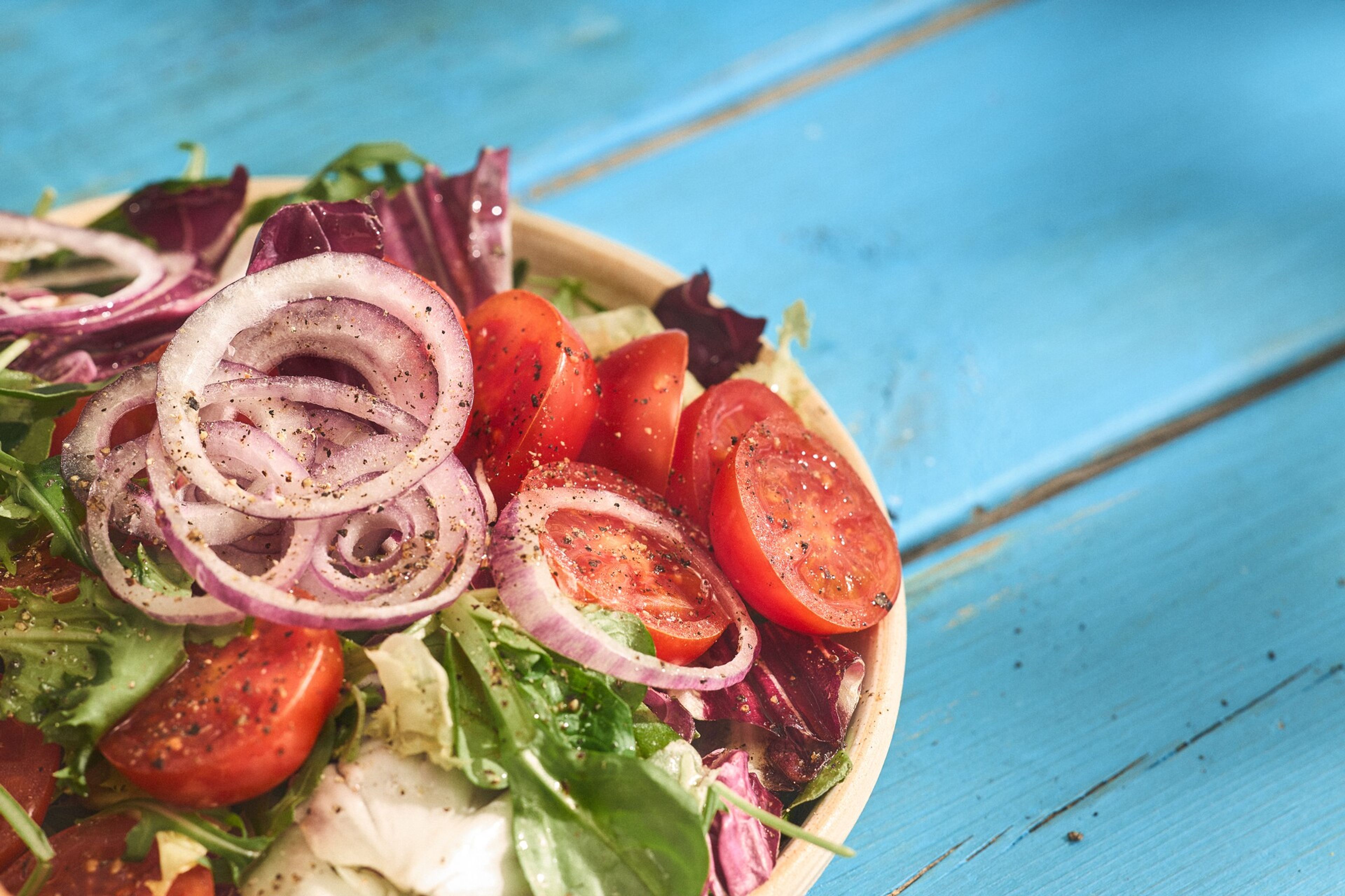 Grekisk sallad med tomat, lök och gröna blad.