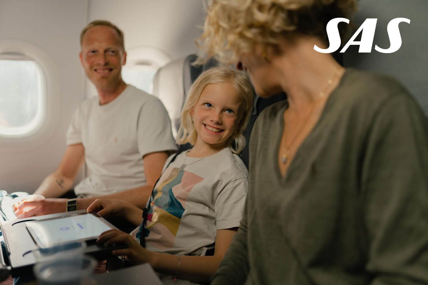 Två vuxna och ett barn i en flygplansmiljö