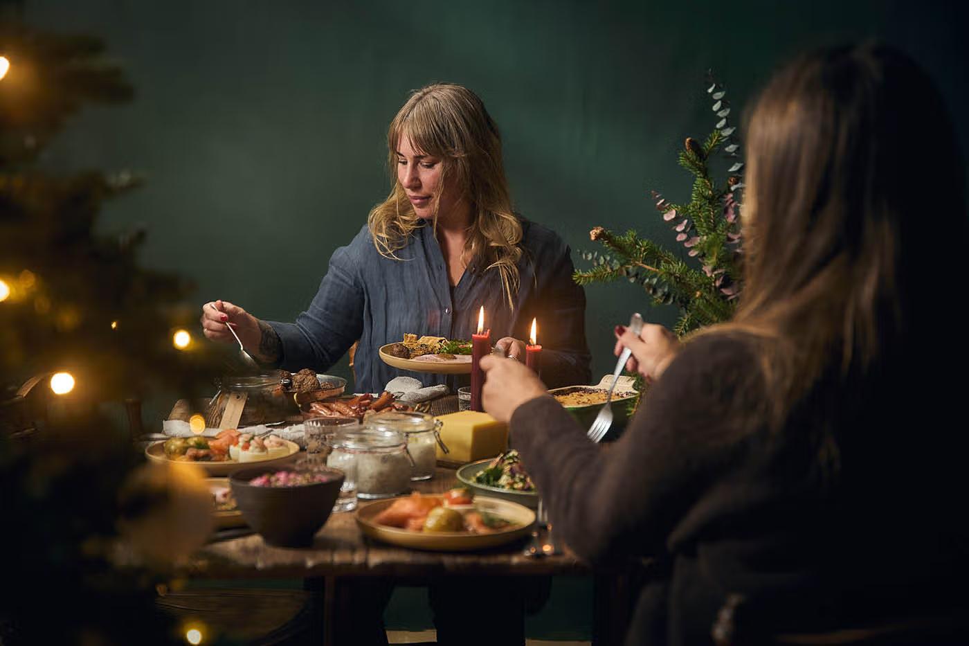 Familj kring bord med traditionellt julbord