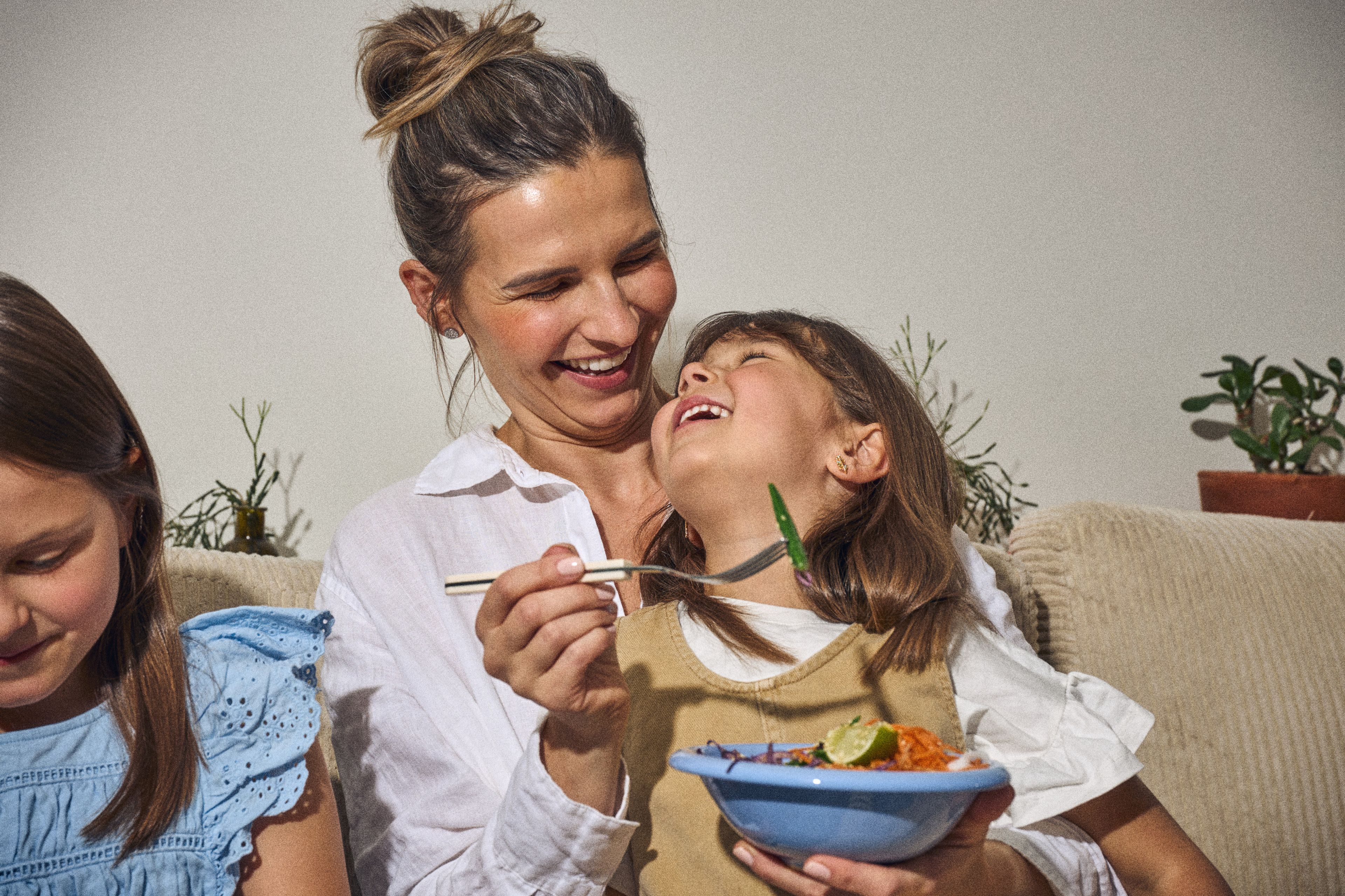 Mamma och dotter delar en middag hemma i soffan