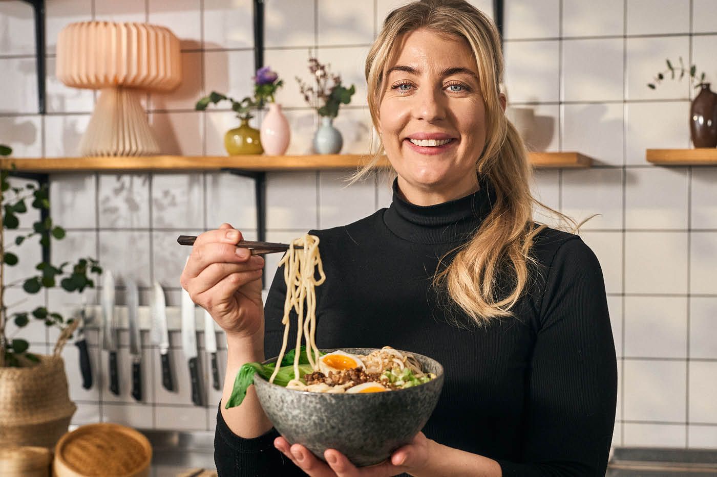 Kocken Frida Ronge i köksmiljö med en skål ramen