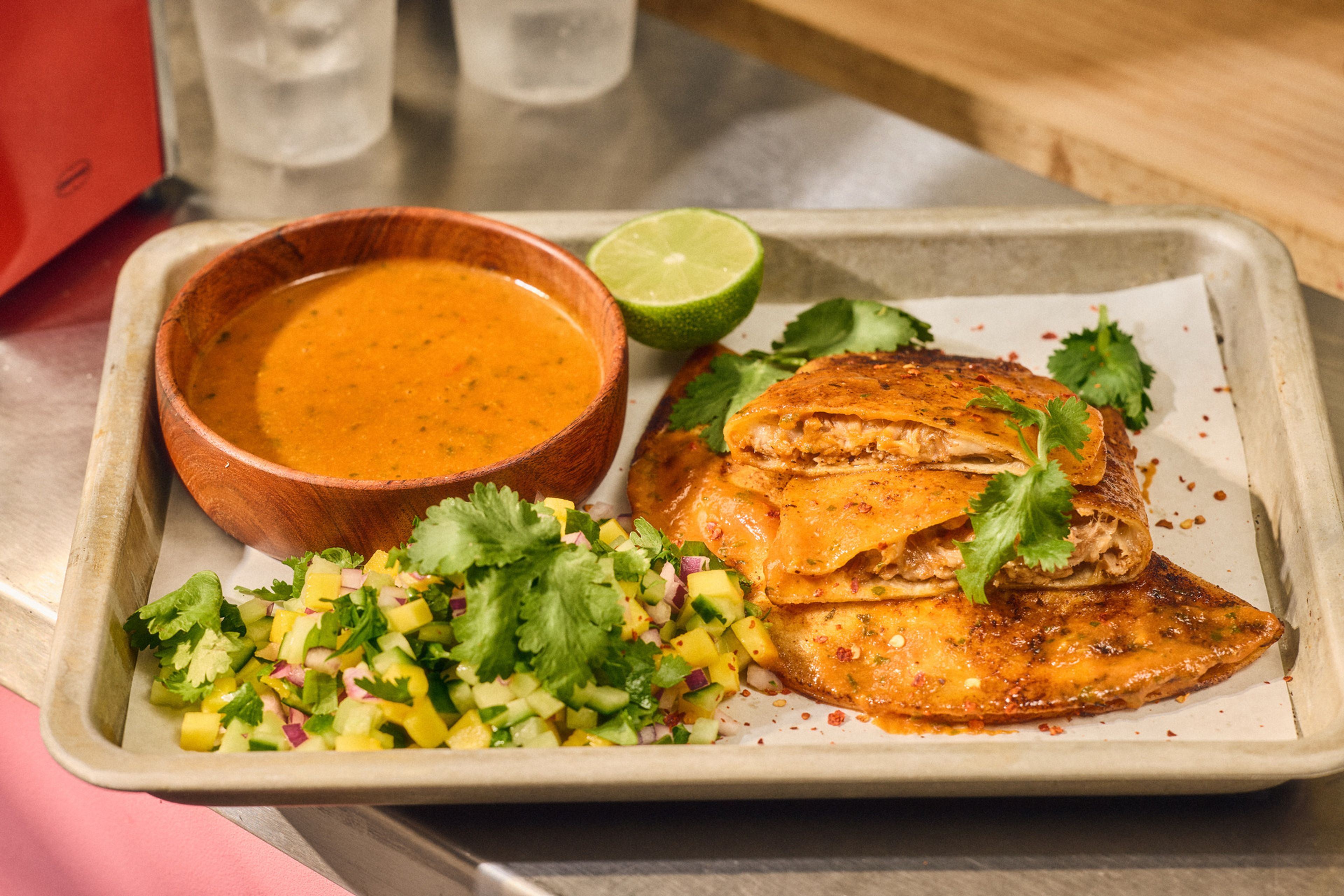 Birria tacos med mangosalsa serverat på en bricka
