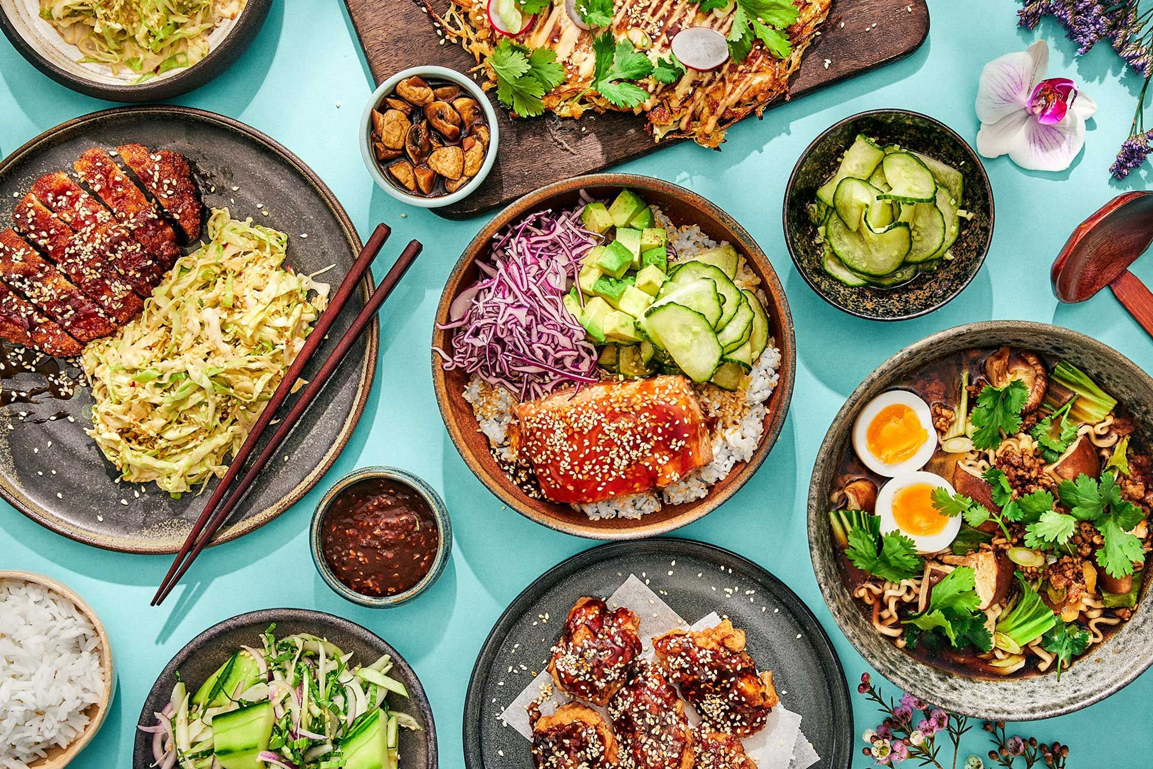 Tallrikar och skålar fyllda med japanska rätter som tonkatsu, donburi och ramen.