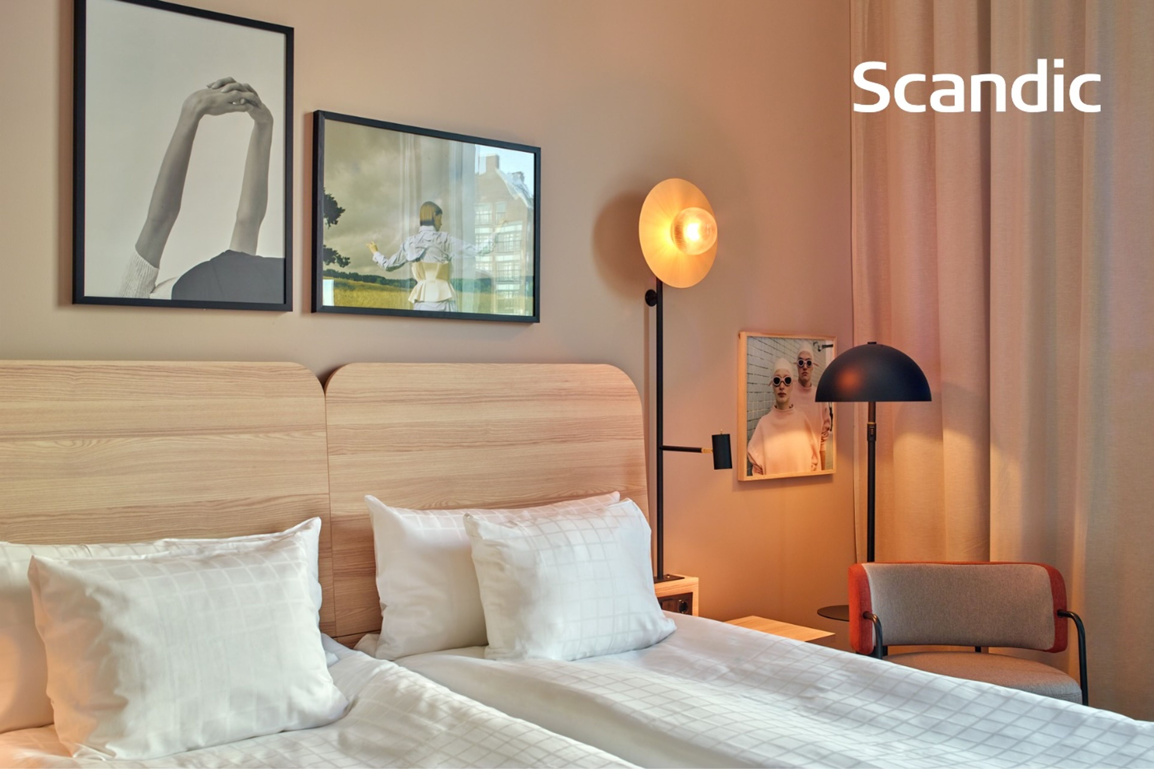 En modern hotellrum med två sängar och stiliga väggkonstverk.