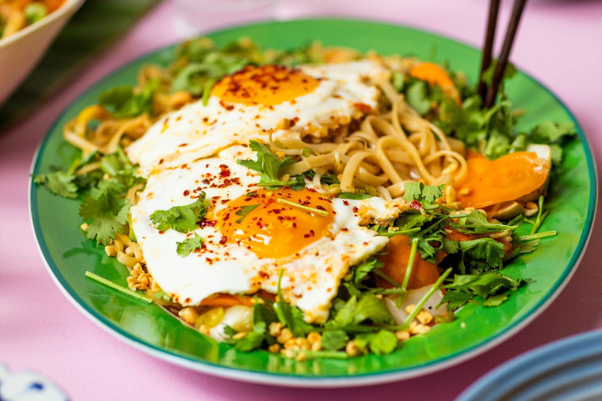 Nudelwok med färska örter och ett stekt ägg med krämig gula