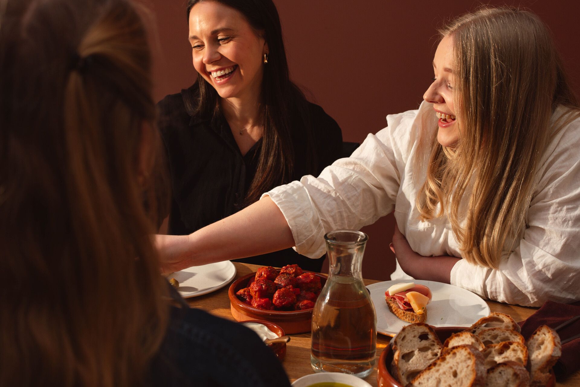 Grinende kvinder rundt om et dækket bord
