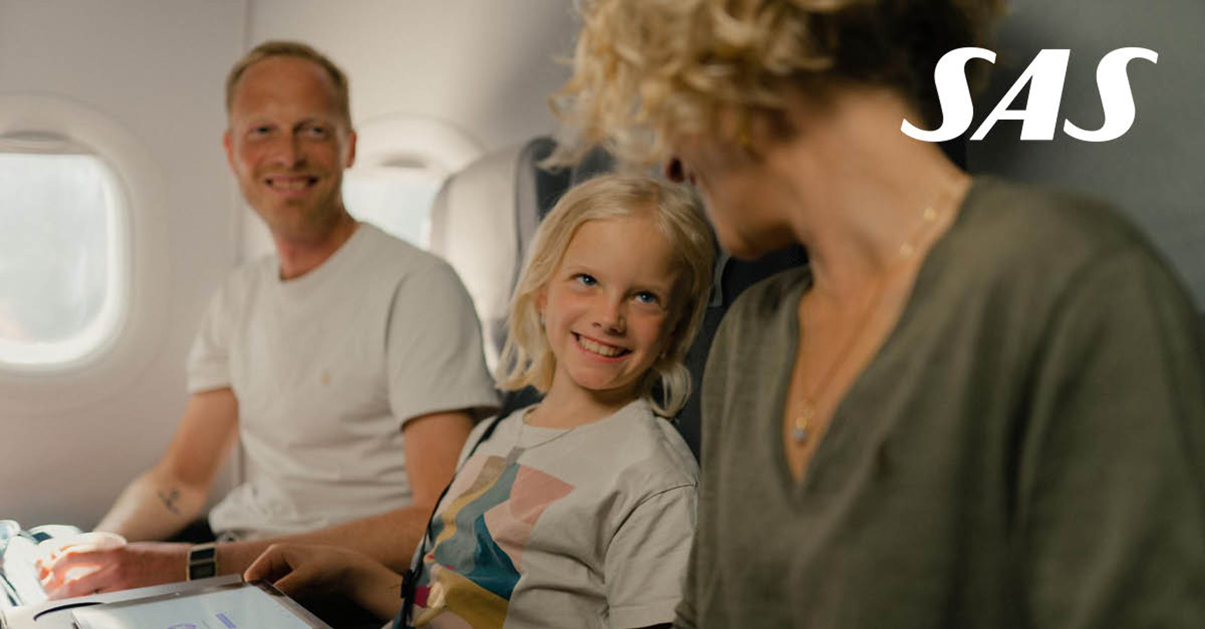 To voksne og et barn i et fly