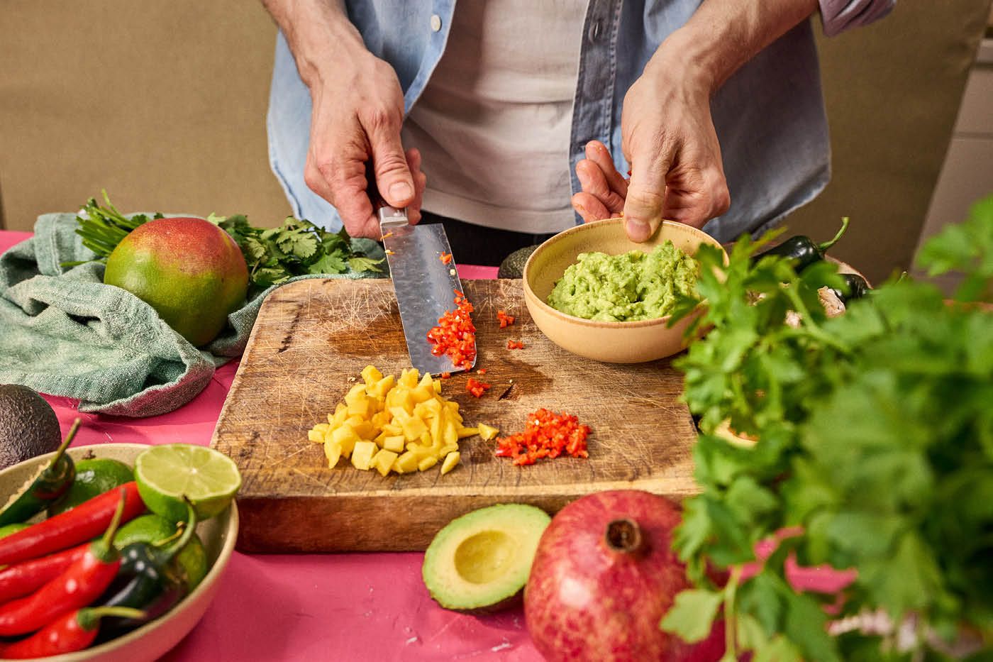 Mango i tern og chili på skærebræt, skål med guacamole.
