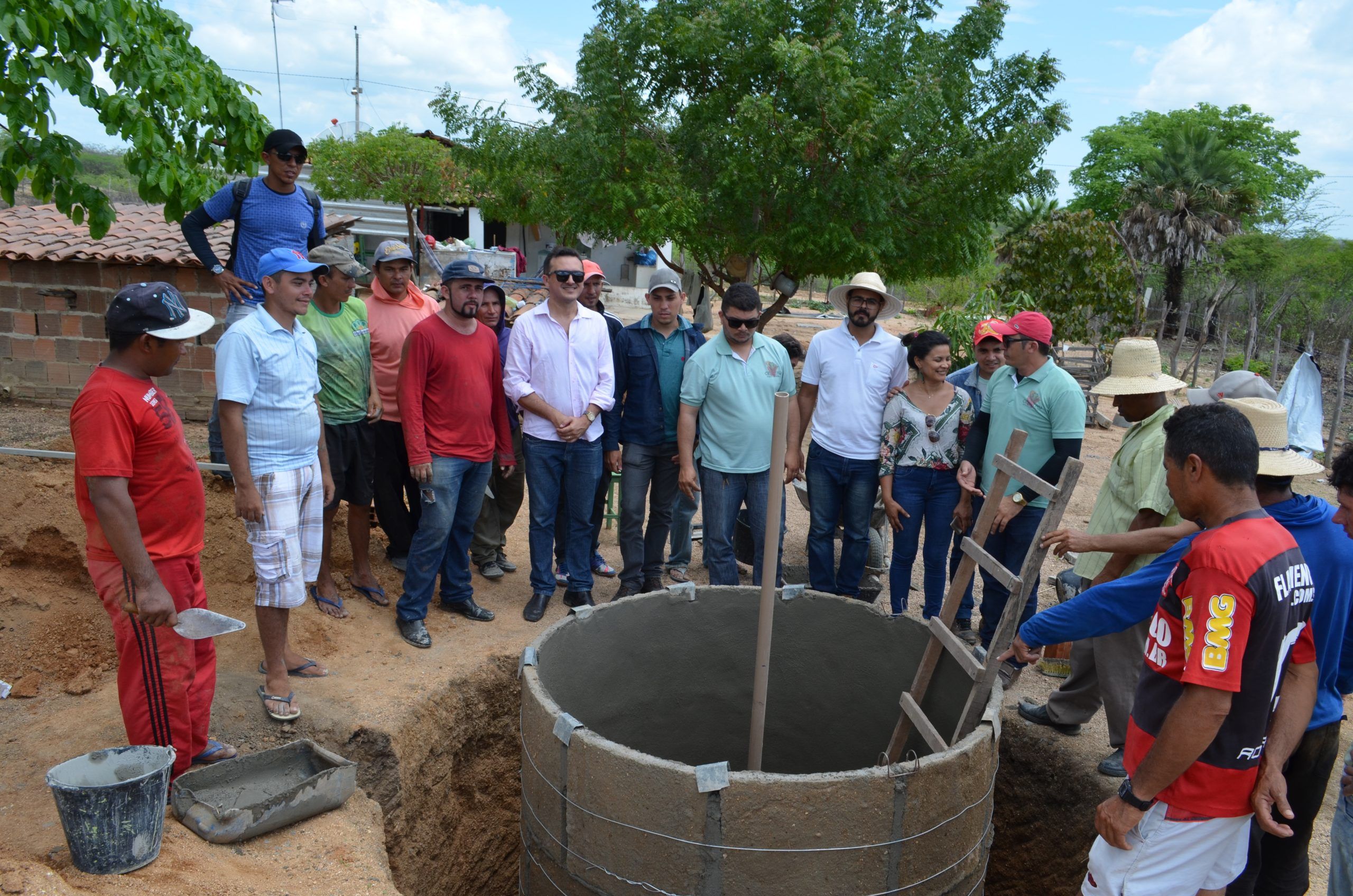 Agricultores e técnicos reunidos em volta de uma cisterna em construção