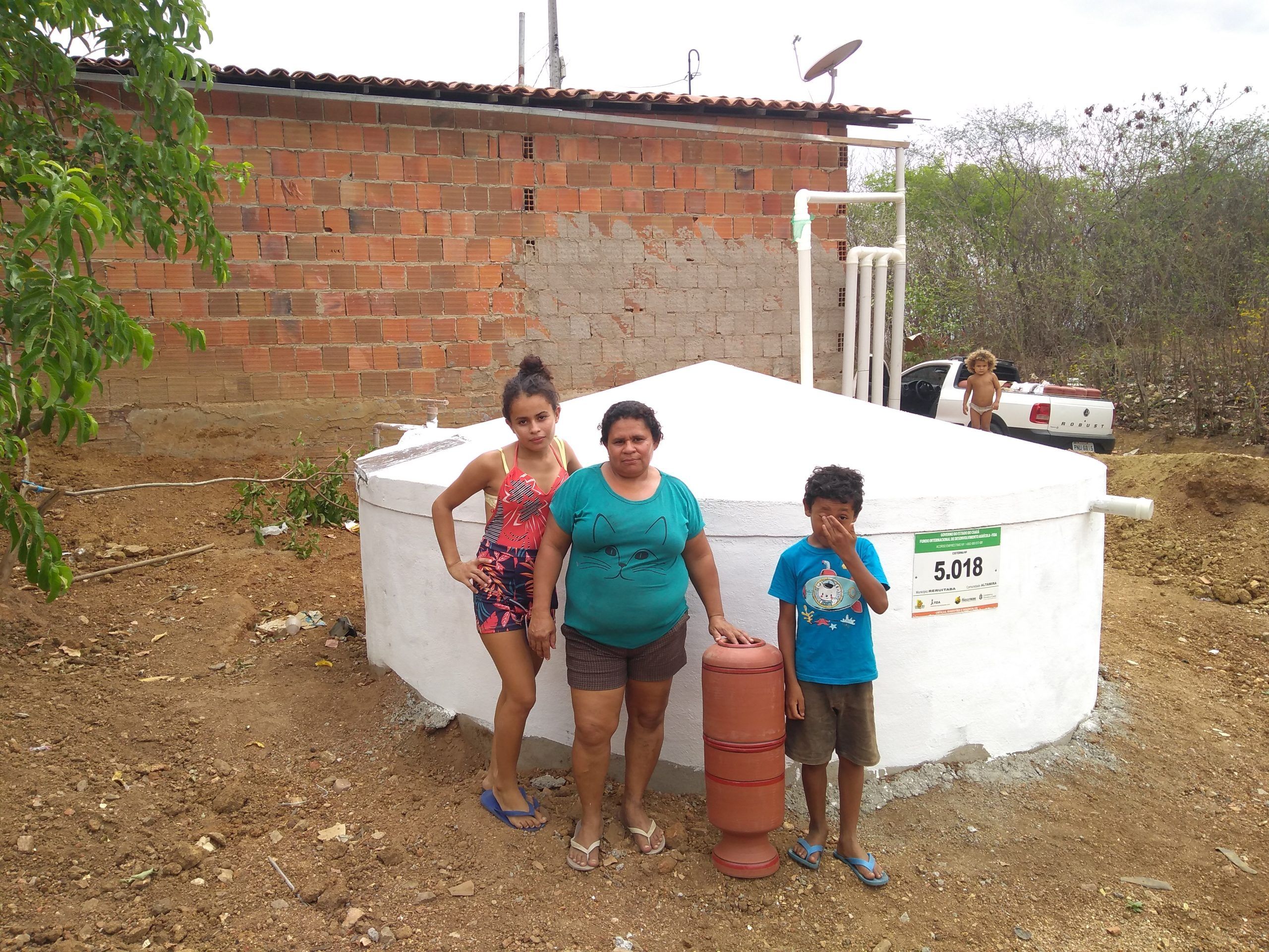 Família reunida em frente à cisterna
