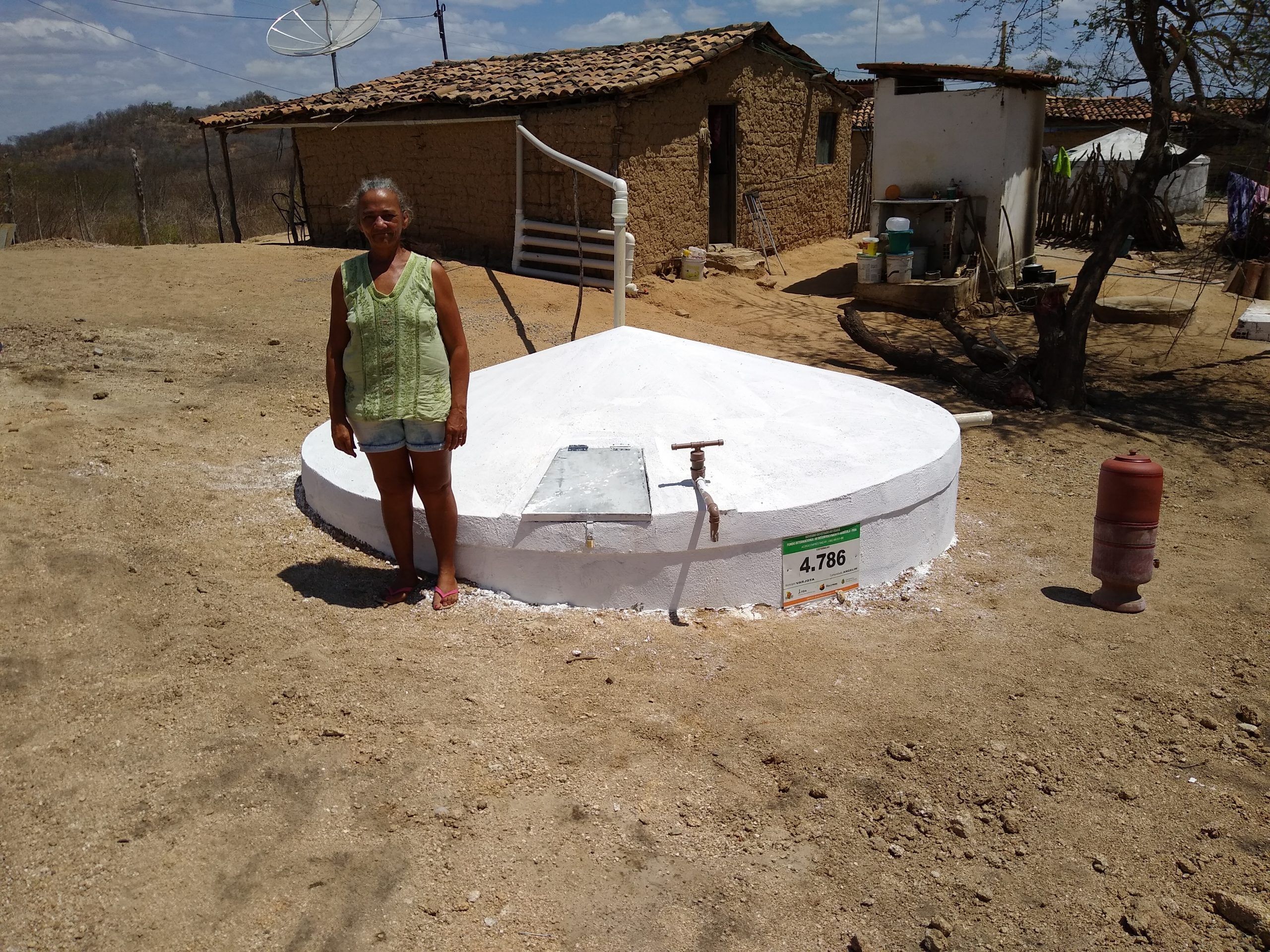 Agricultora diante de uma cisterna de placas