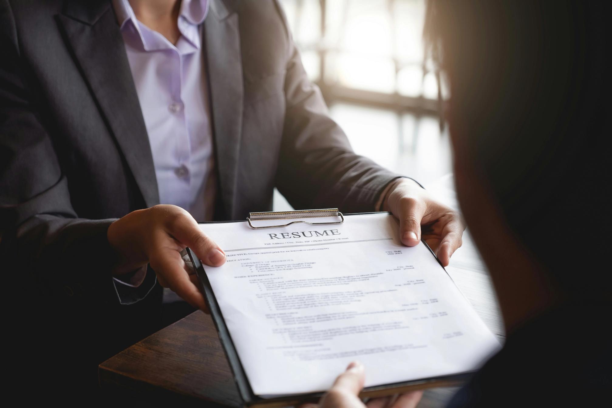 Resume being handed to a recruiter
