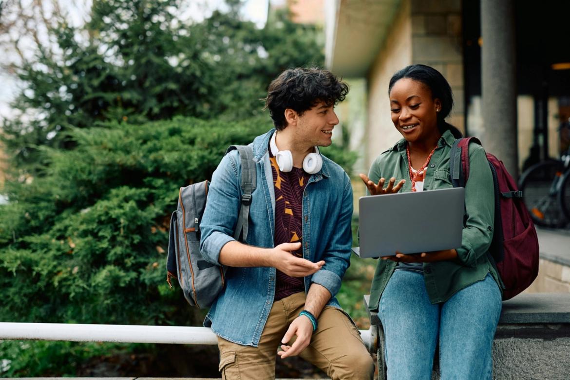 Two university students looking at a laptop
