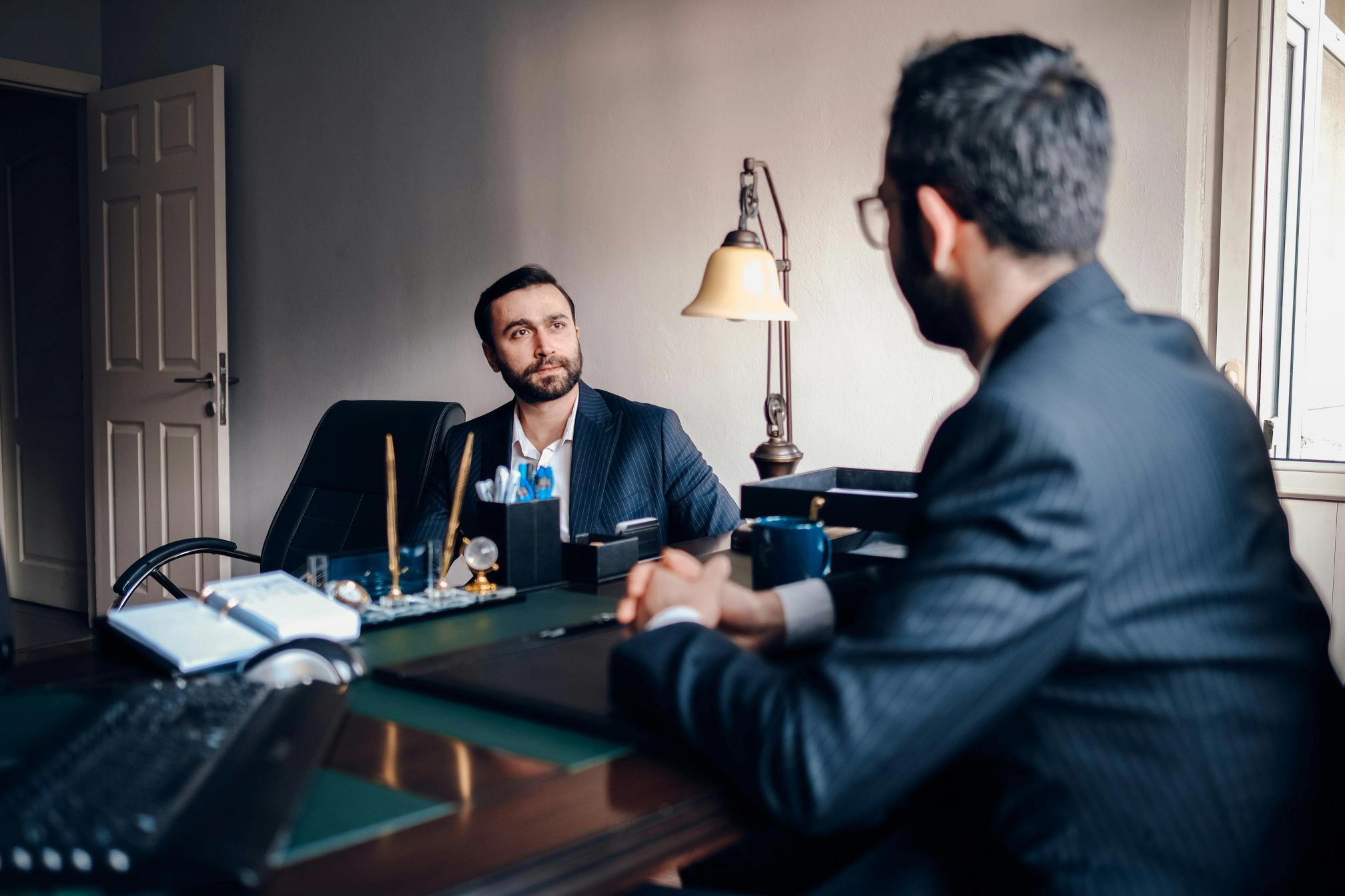 A man in a suit interviewing another man in a suit