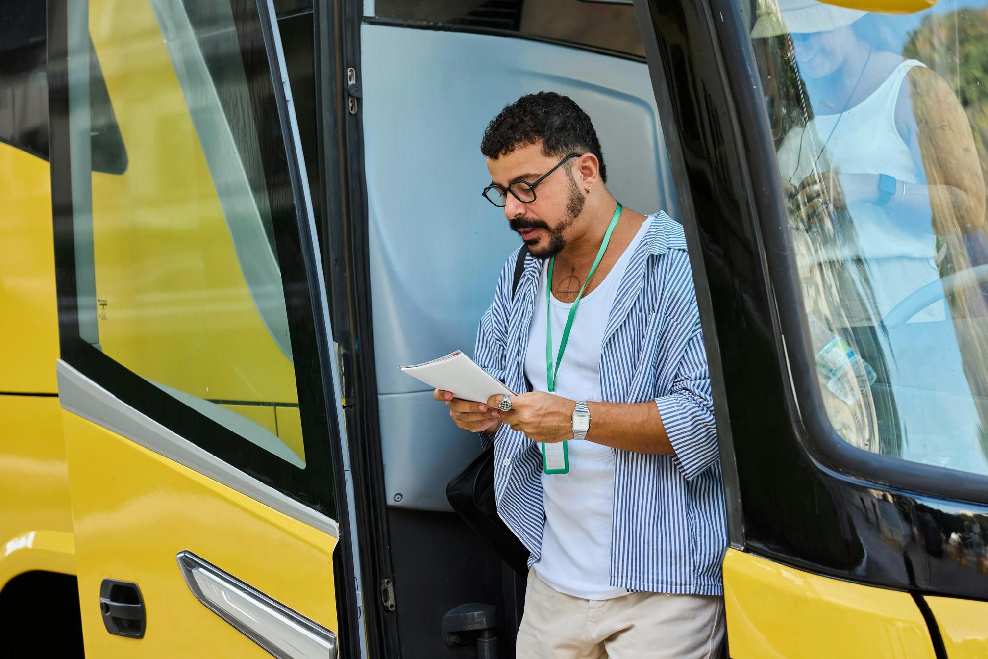 Man standing in the doorway of a yellow bus