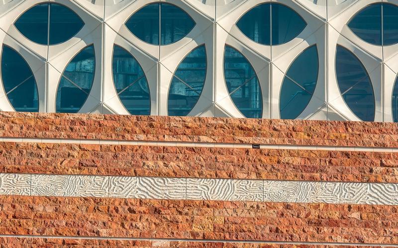 A modern architectural facade with geometric brick and glass patterns.