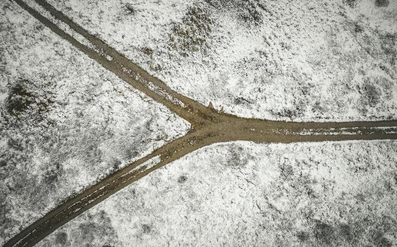 Aerial photo of a snowy landscape with a forked dirt road near Bindslev in northern Denmark.